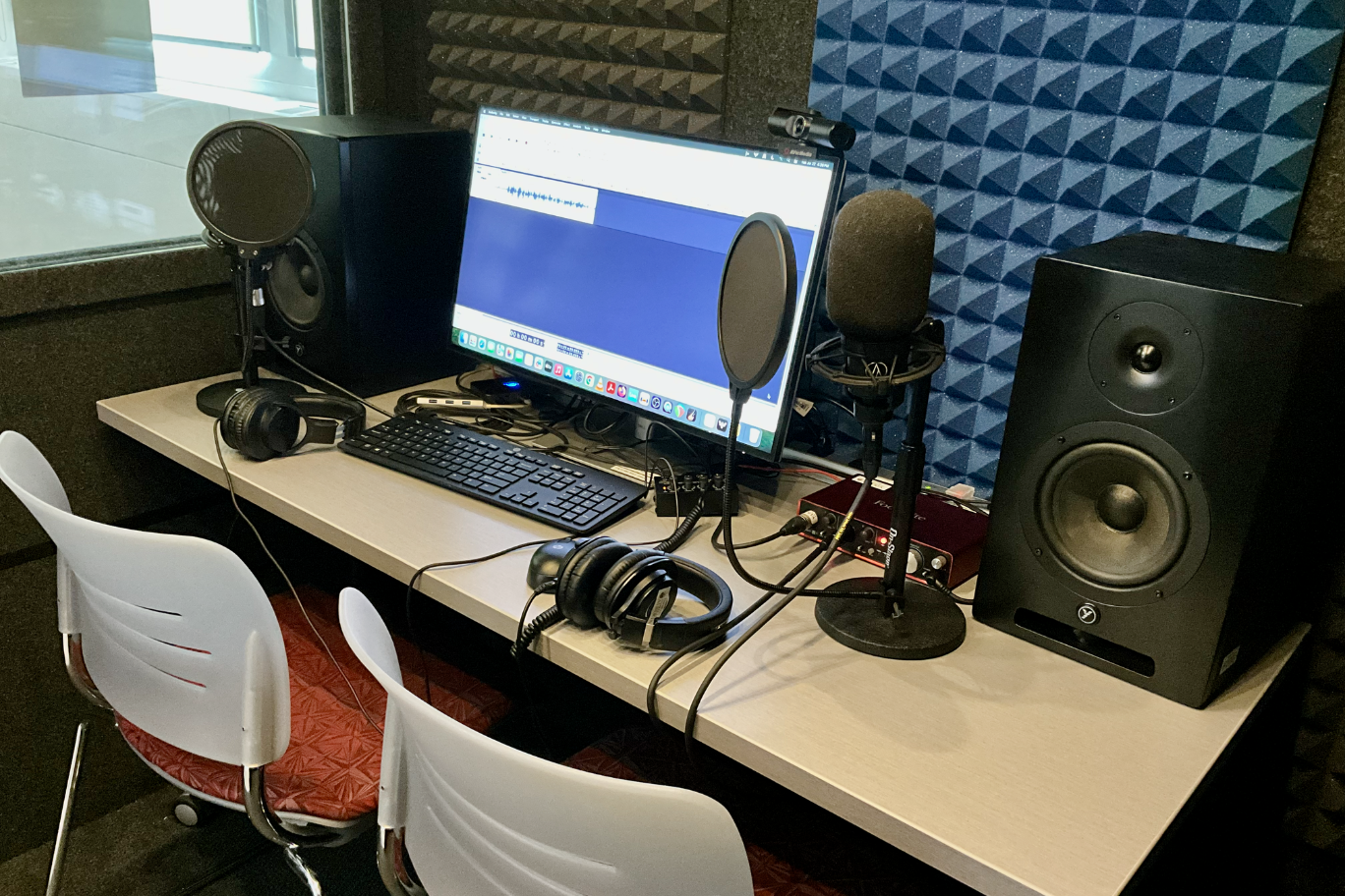 Interior of the DSC's recording booth with microphones, speakers, and computer.
