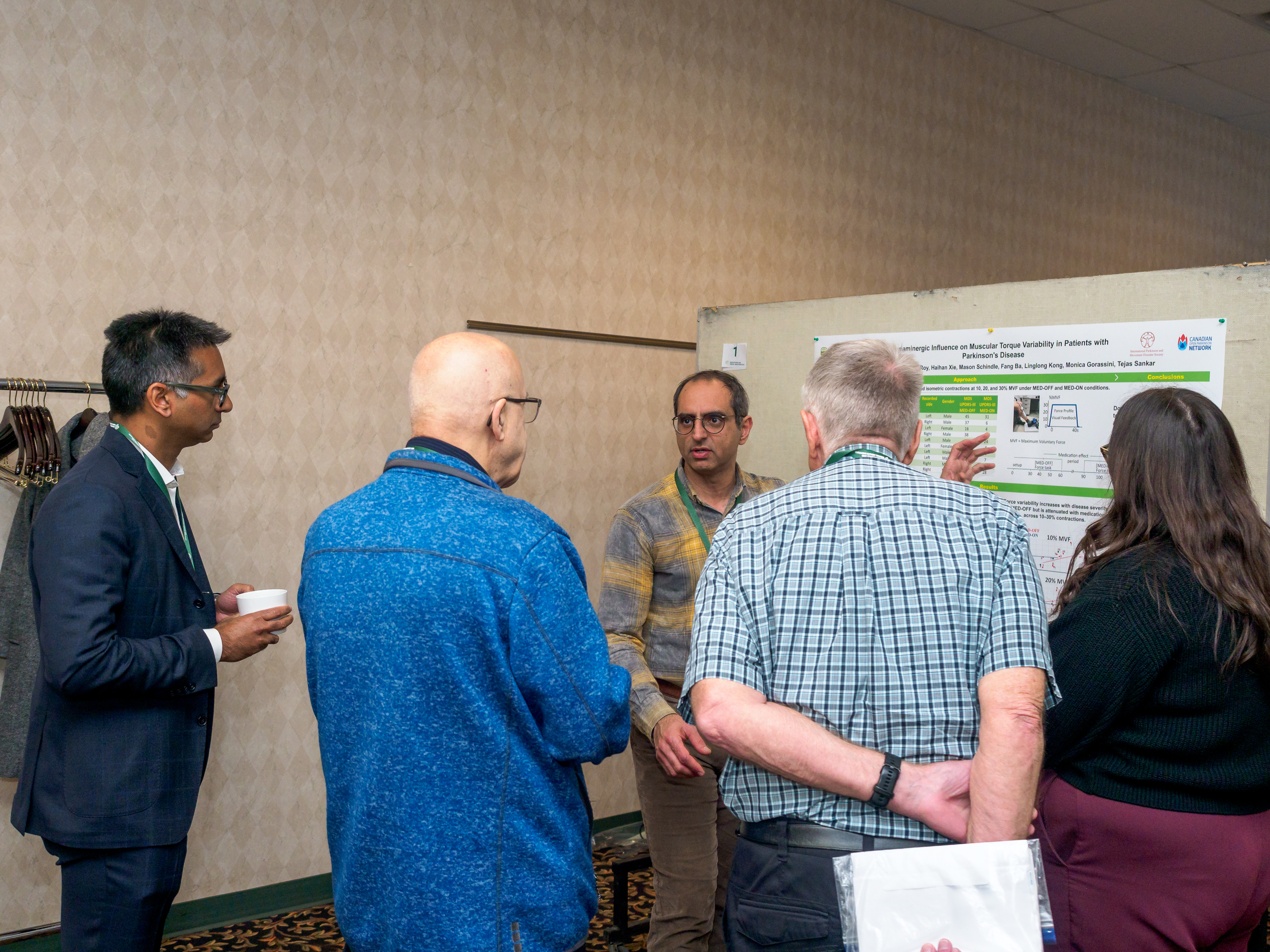Group of people standing around a research poster