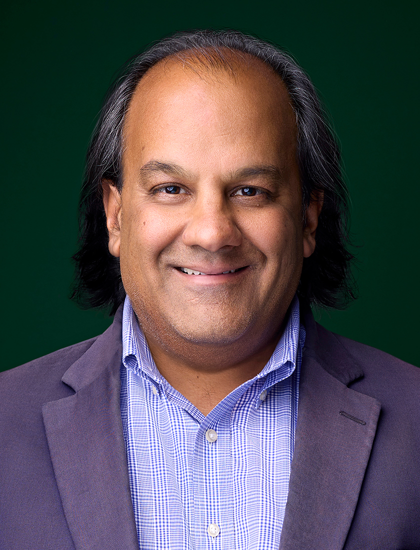 colour photo of Atul Malhotra, dark green background