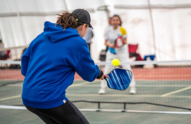 Photo of a young woman playing pickleball