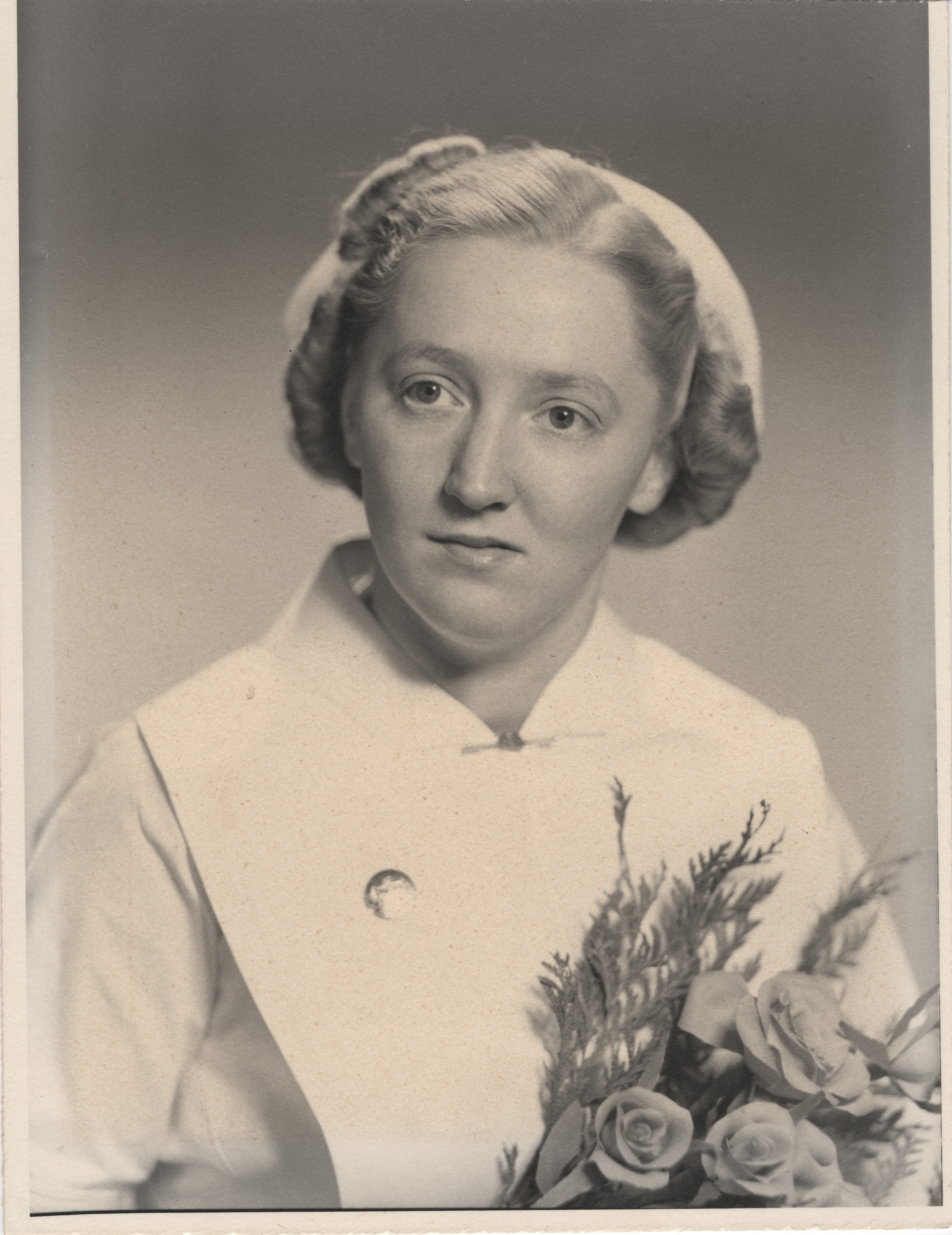  Kathleen Ritchie (nee Newman) in uniform poses with flowers.