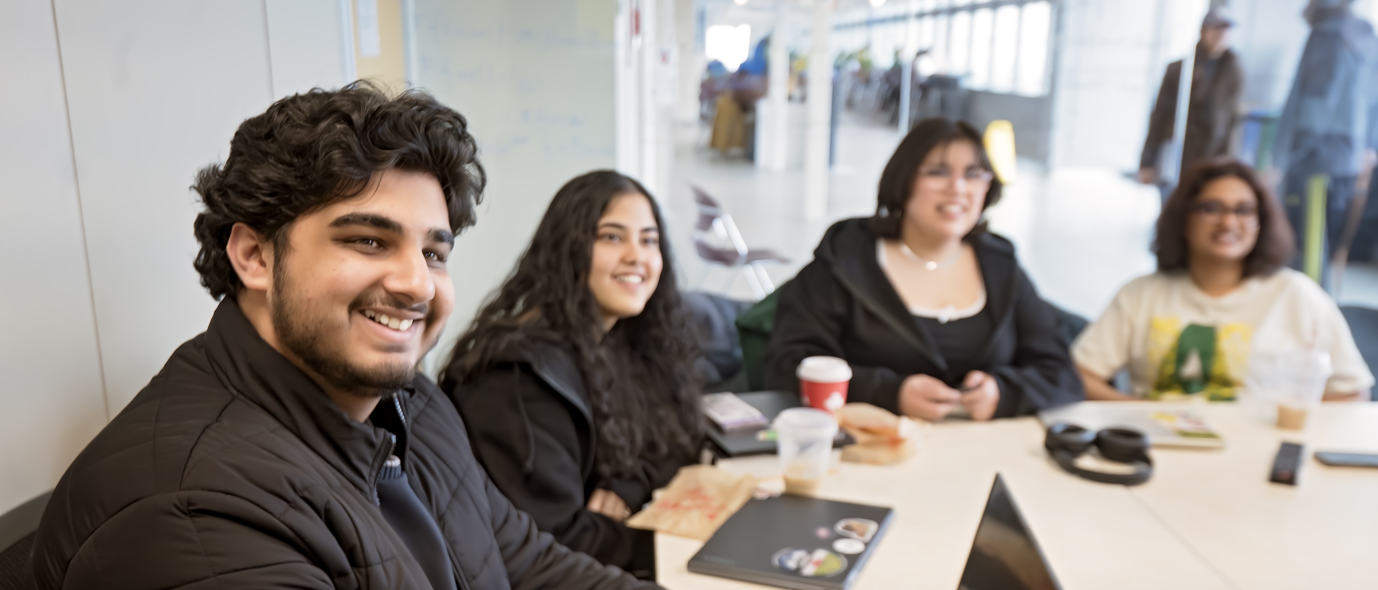 Numerous smiling students on laptops