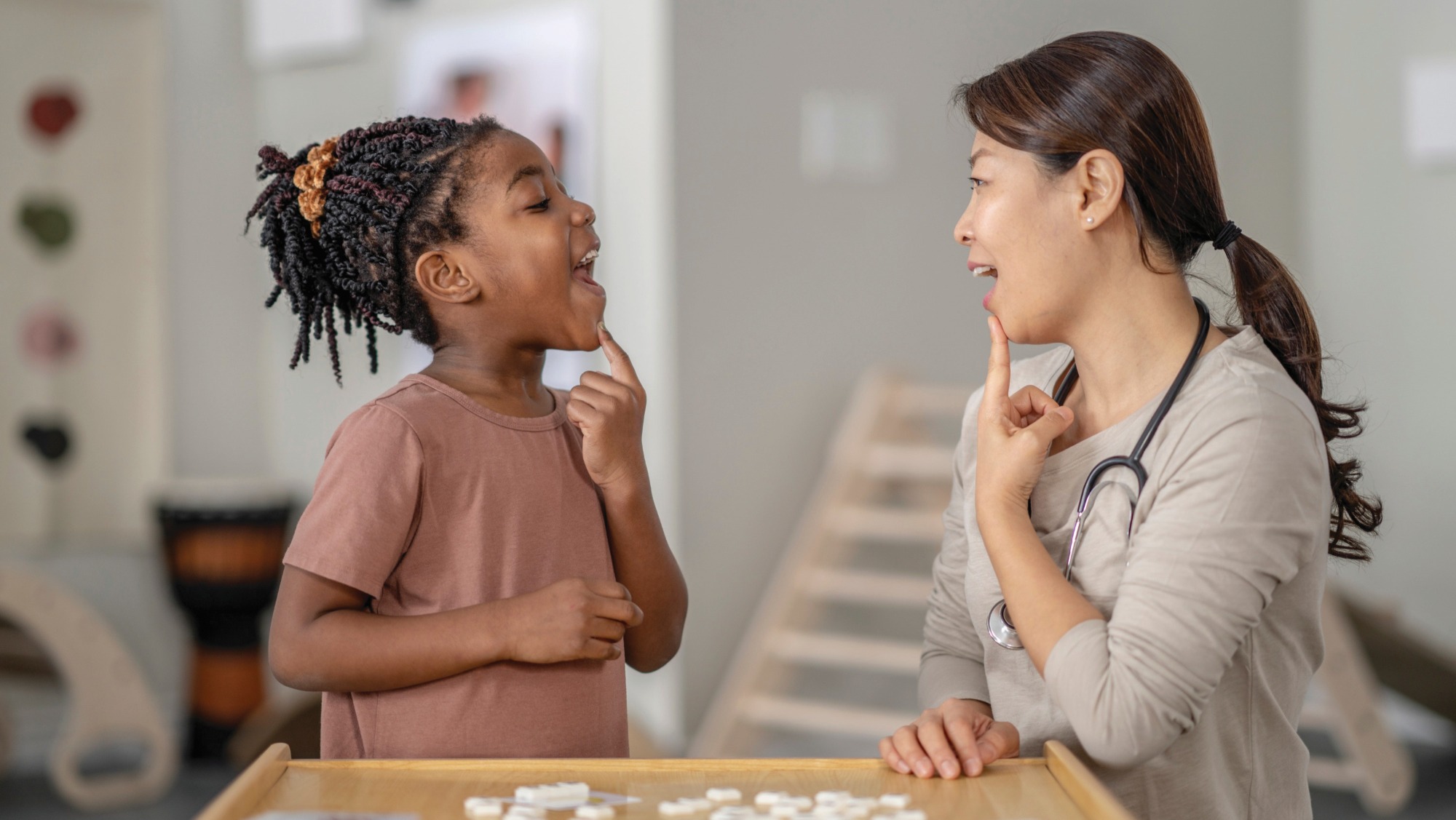 A speech language pathologist performing an exercise with a child patient