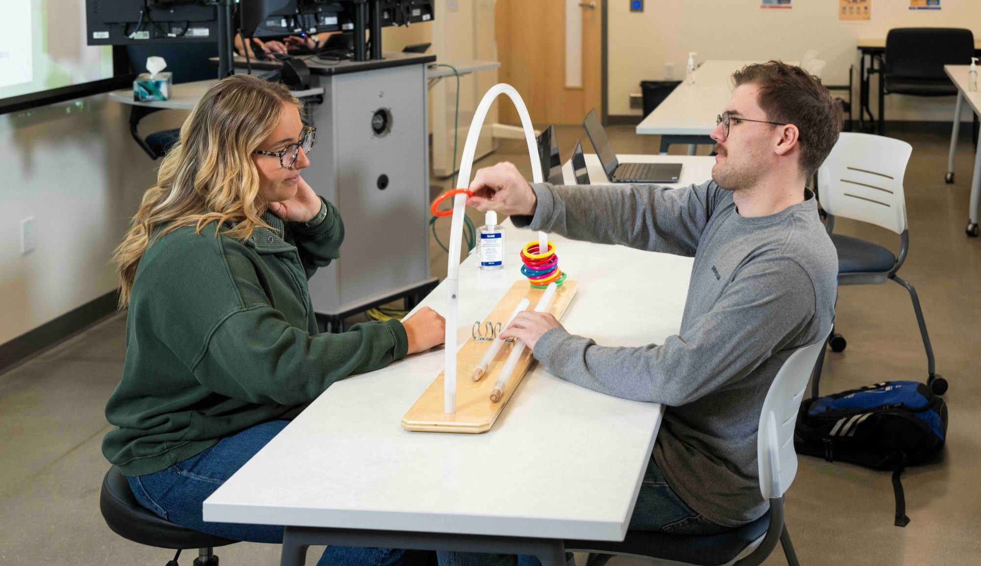 An occupational therapist working on a puzzle with a young man