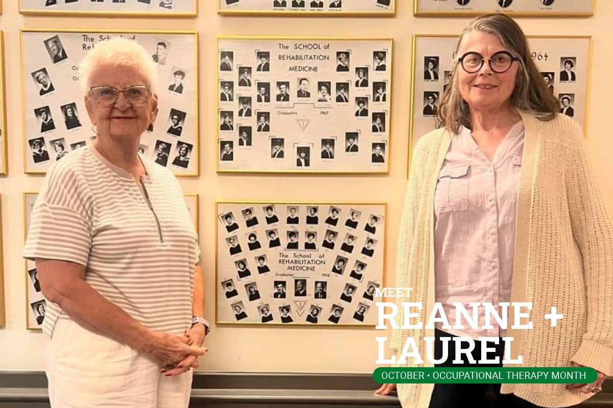 Reanne and Laurel standing next to their graduating class photo.