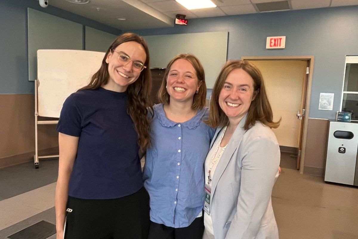 Three people standing in a clinic setting.
