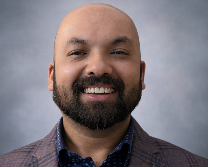 Professional photo of Tahmid Huq Easher smiling warmly wearing a grey suit
