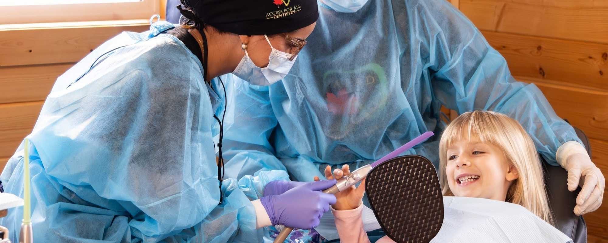 Patient smiling at a student while in the dental chair