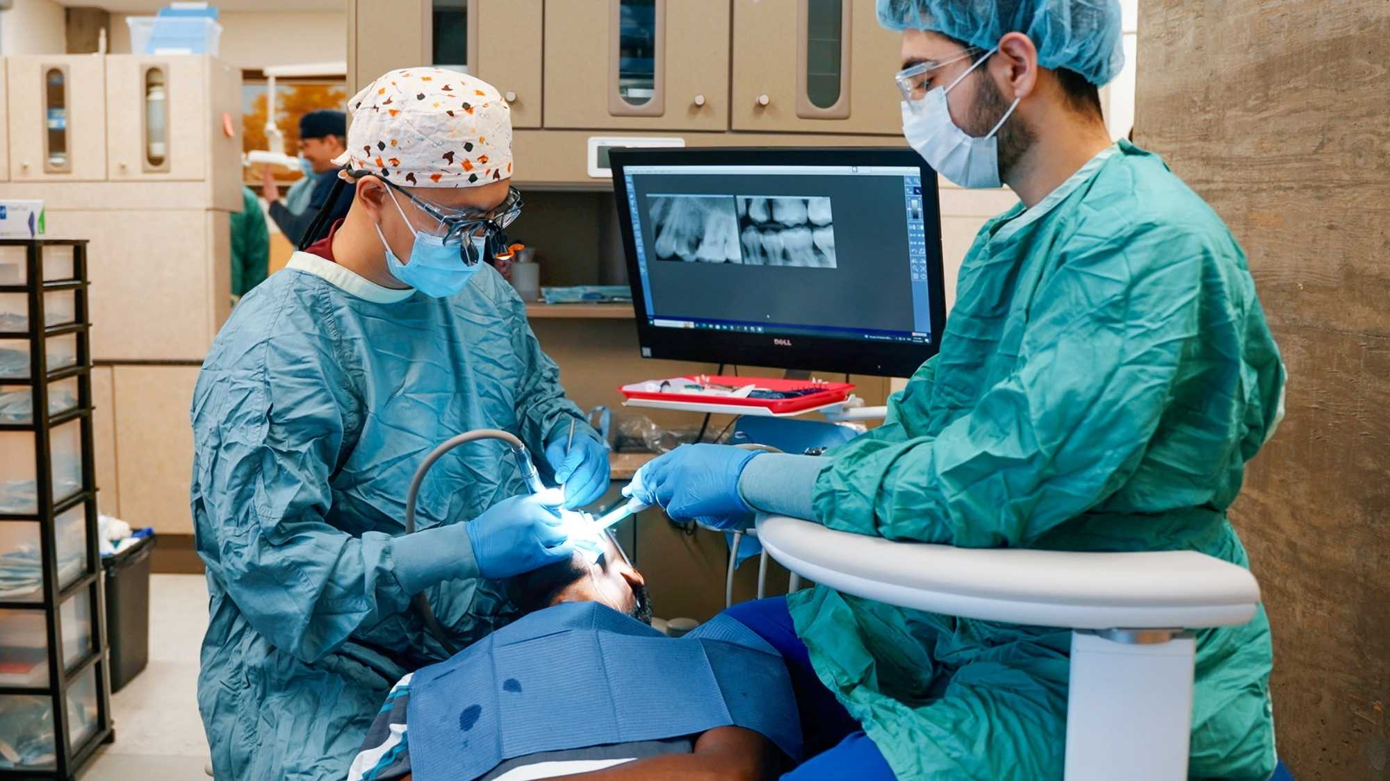 Two students in the SHINE clinic with a patient