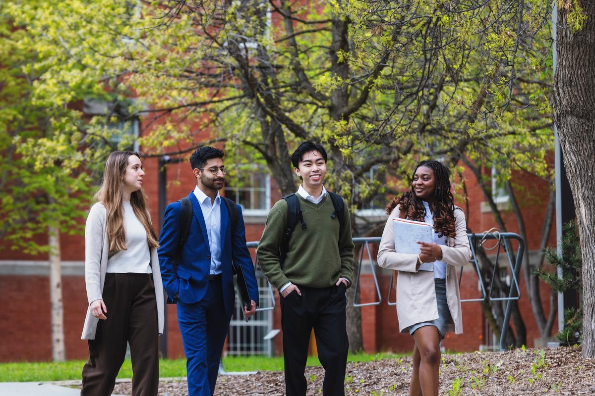 Group of students walking outside in front of trees