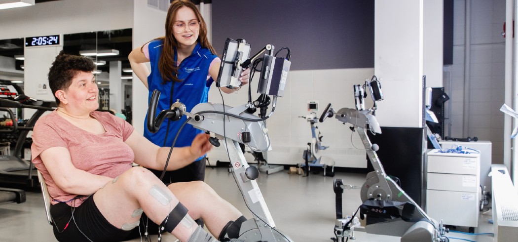 Woman using a recumbent stationary bike with a fitness instructor. 