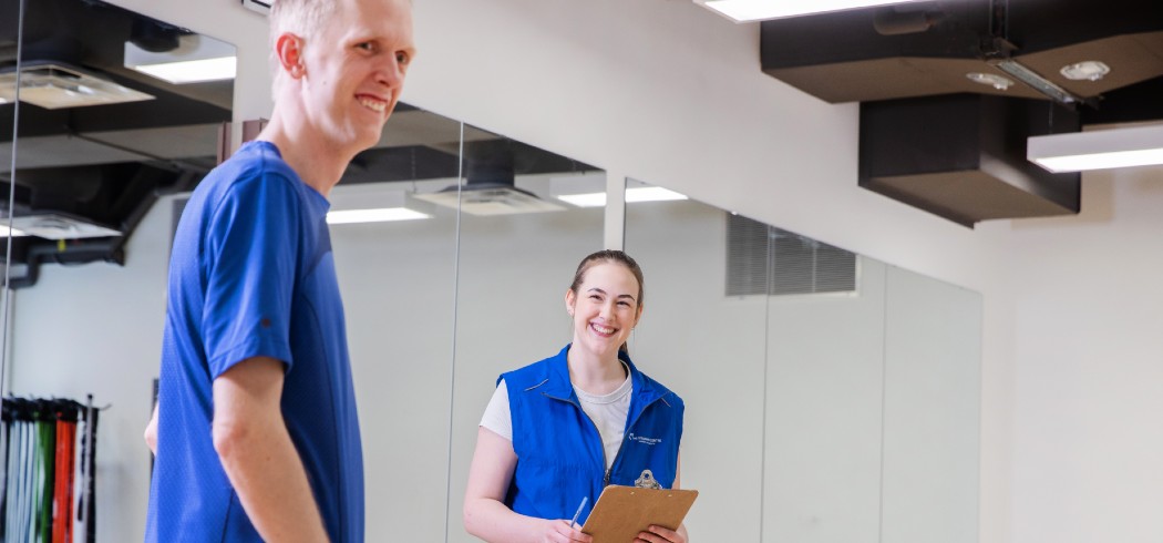 Man smiling in a room with a fitness instructor