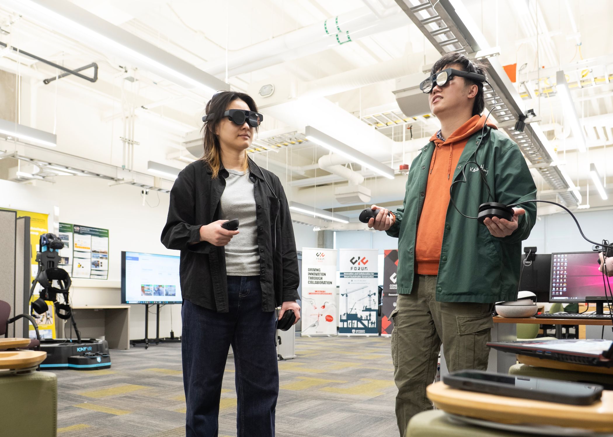 Graduate research assistant fellows Kexin Liu and Zeyu Mao conduct an augmented reality collaboration experiment, sharing an AR environment using smart glasses and handheld controllers.