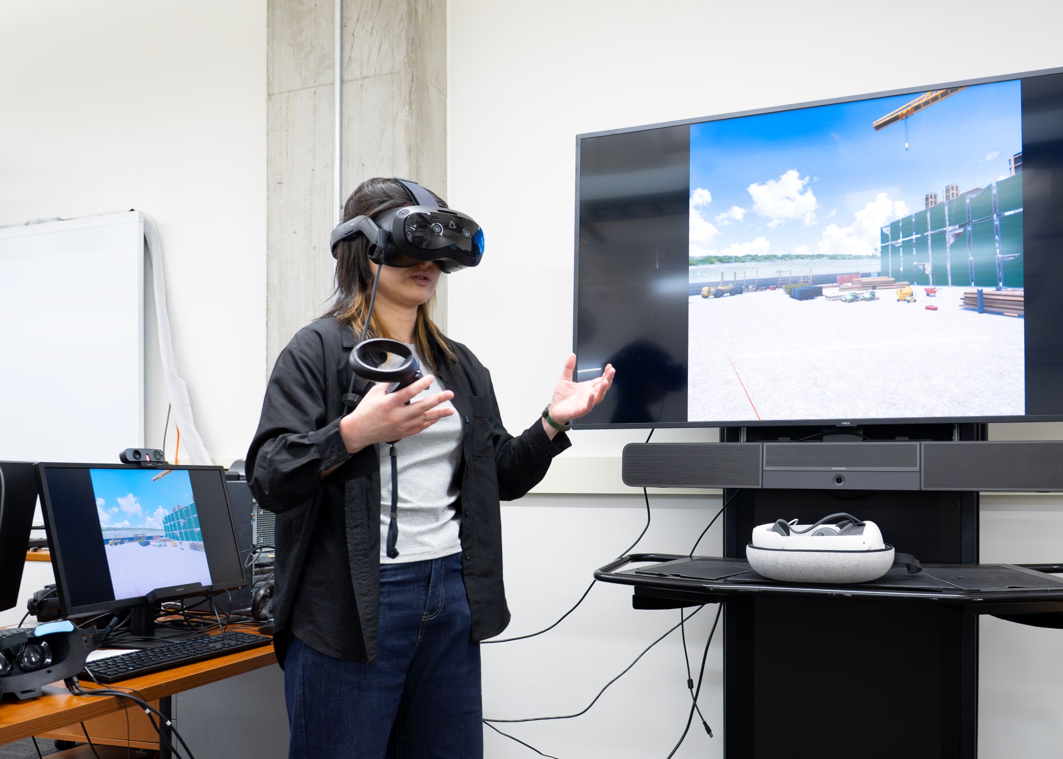 Graduate research assistant fellow Kexin Liu participates in a VR construction experiment, navigating and interacting with a simulated construction site environment.