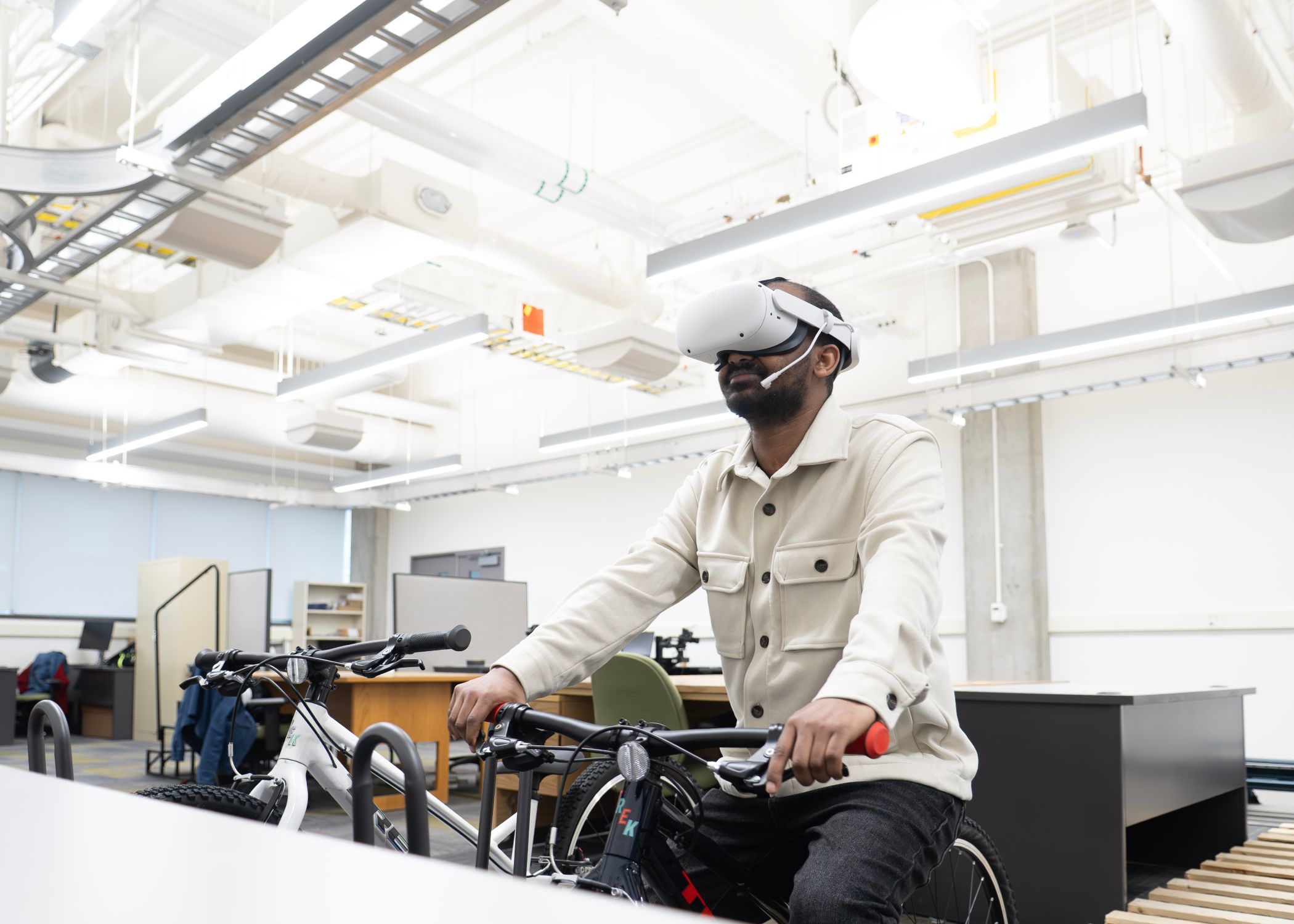 Shambel Assefa Esheti, a graduate research assistant fellow, uses a VR headset that simulates a cycling experience during a transportation system experiment.