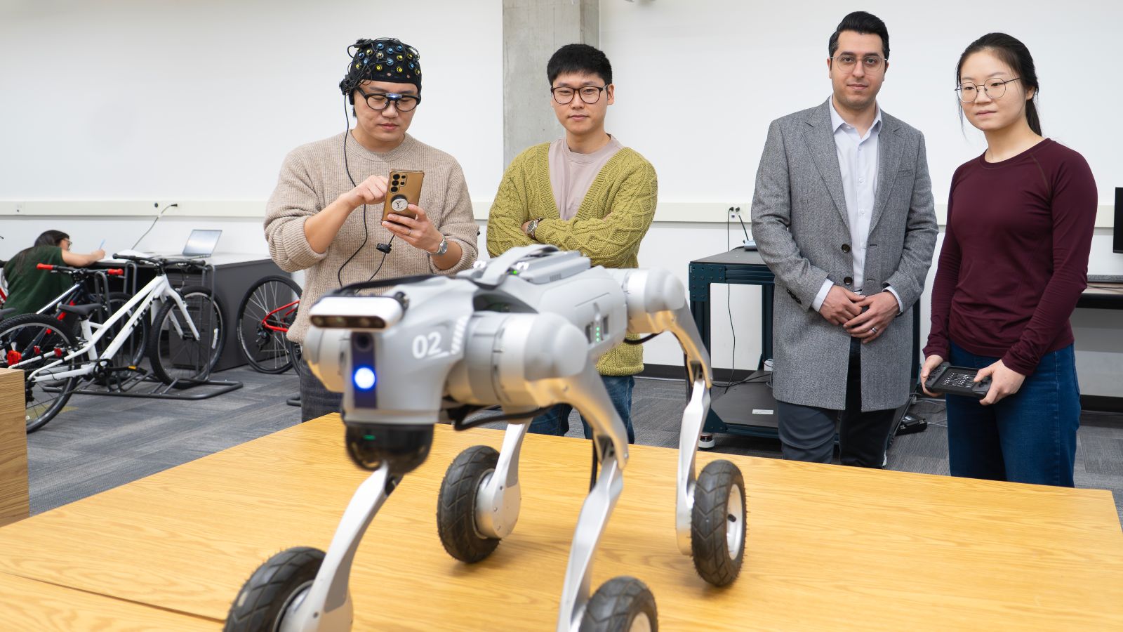 Left to right: postdoctoral fellow Heejae Ahn, assistant professor Gaang Lee, CIC executive director Ali Golabchi and graduate teaching assistant Yuezhen Gao operate a quadruped wheeled robot in a robotics experiment.