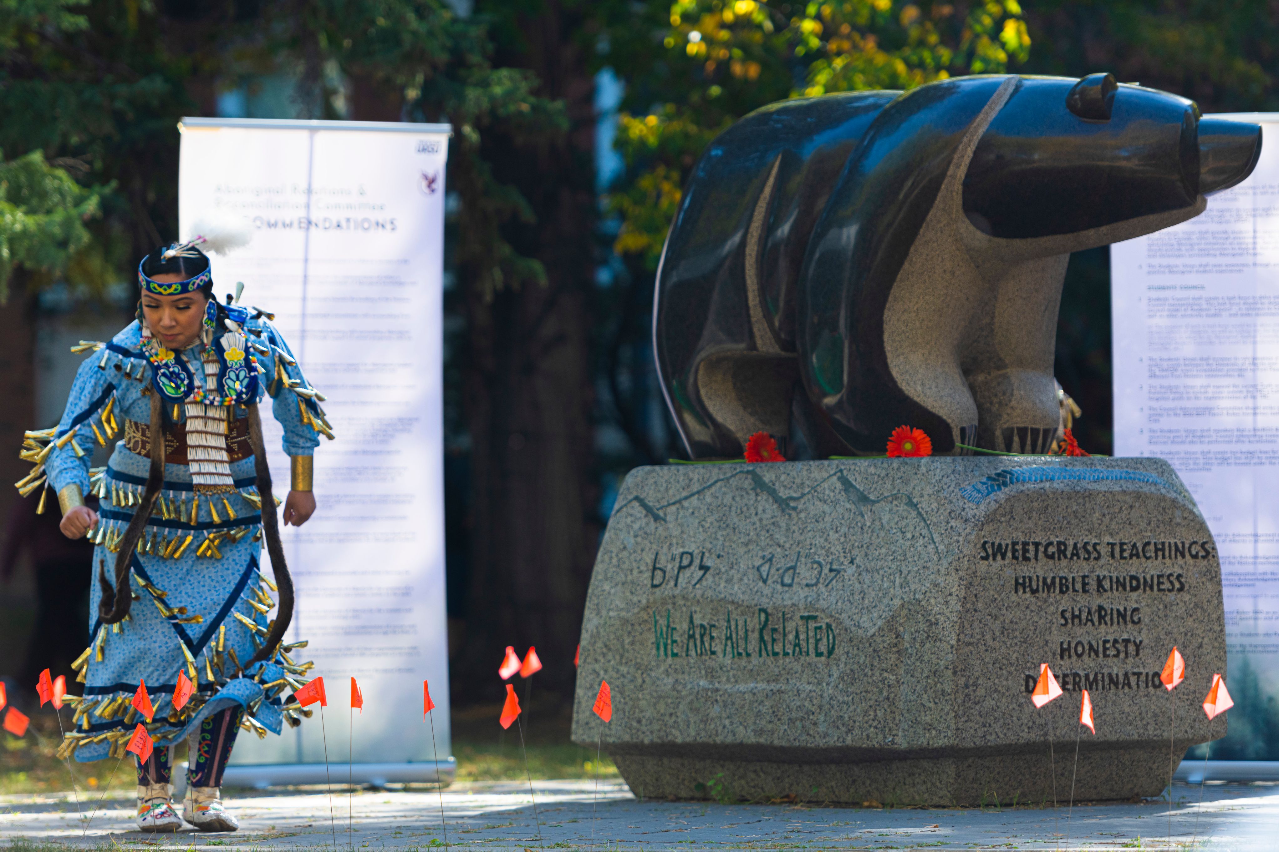 Danni Okemaw dances beside the Sweetgrass Bear during the 2022 Orange Shirt Day event.