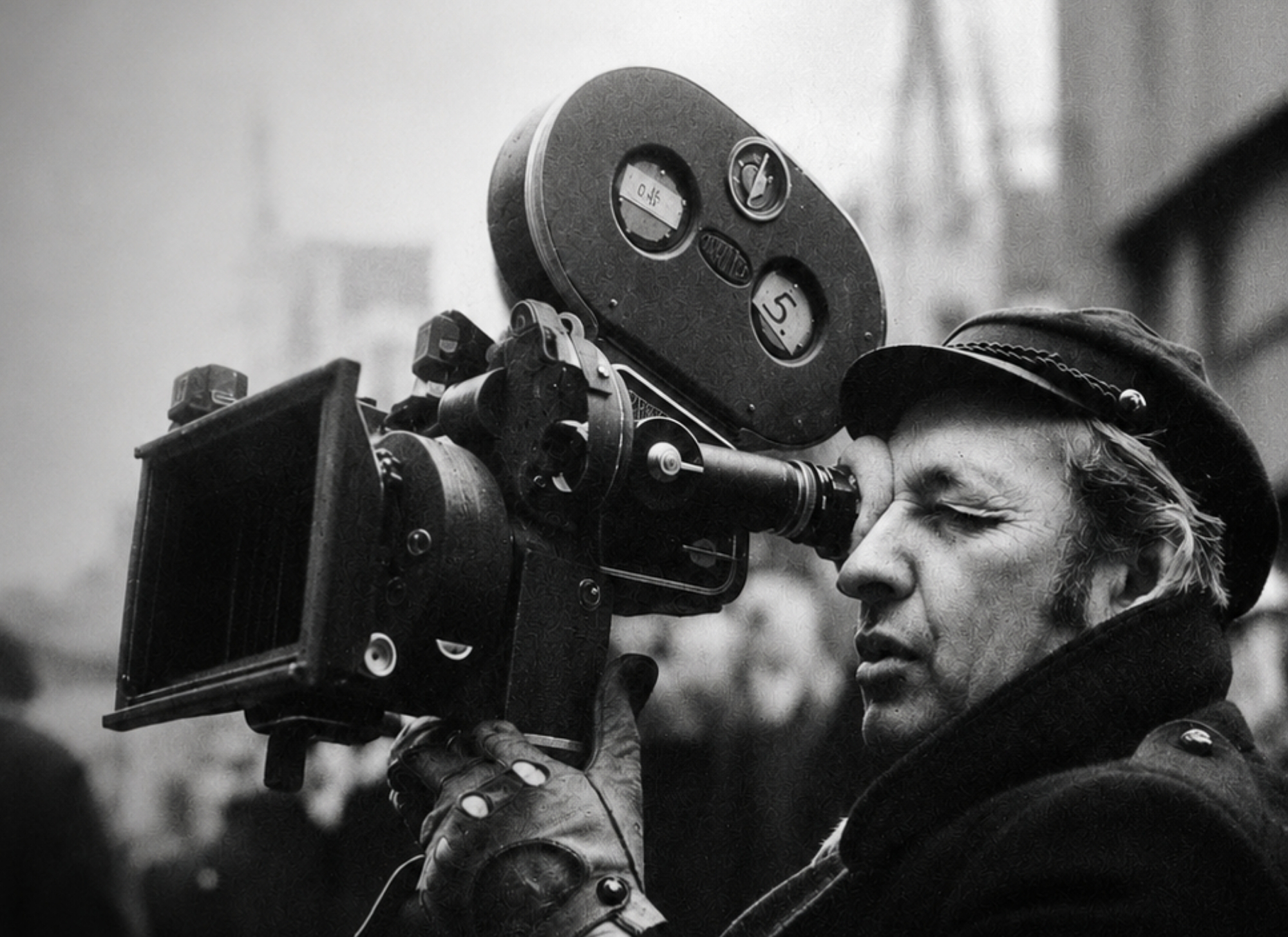 Black and white photo of Polish filmmaker Andrzej Wajda behind a camera.