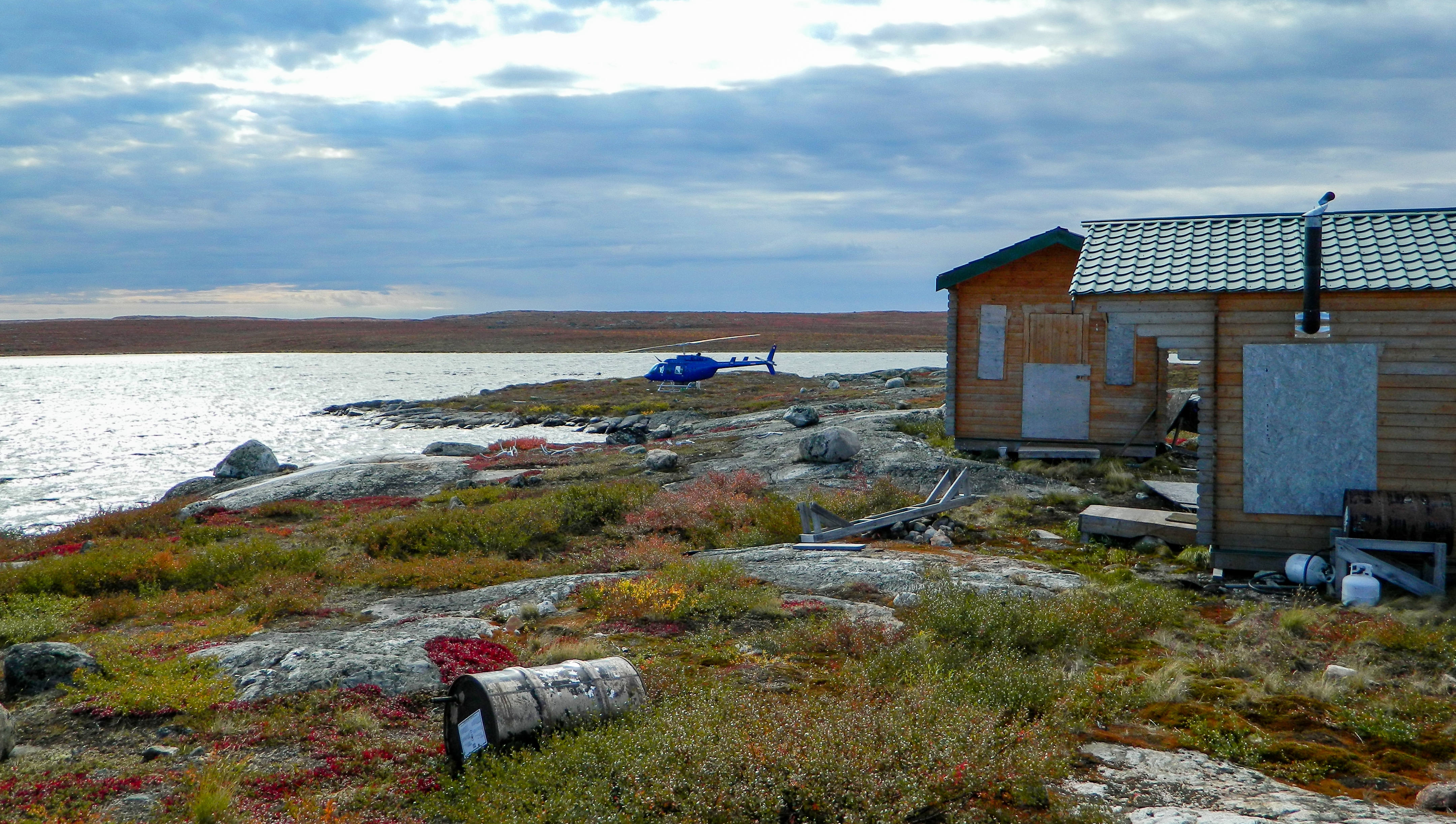 A helicopter by derelict buildings in the remote NWT