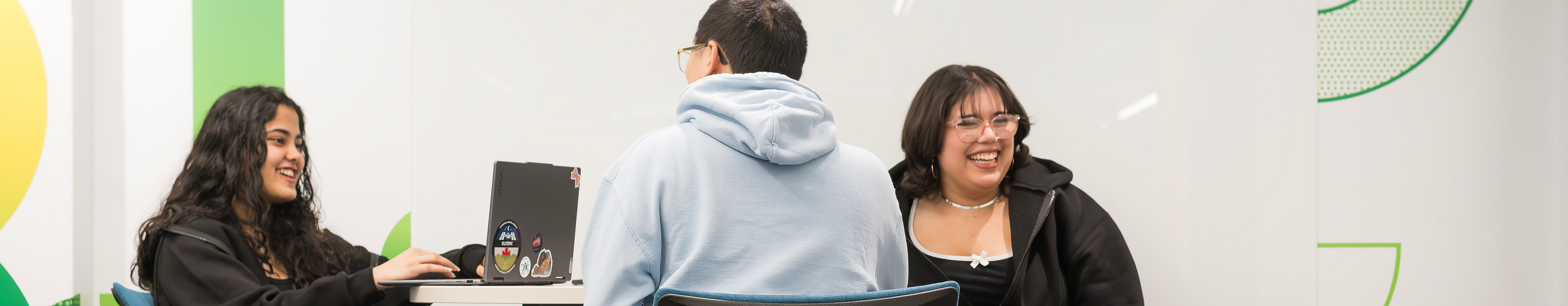 Students laugh while studying in a study area.