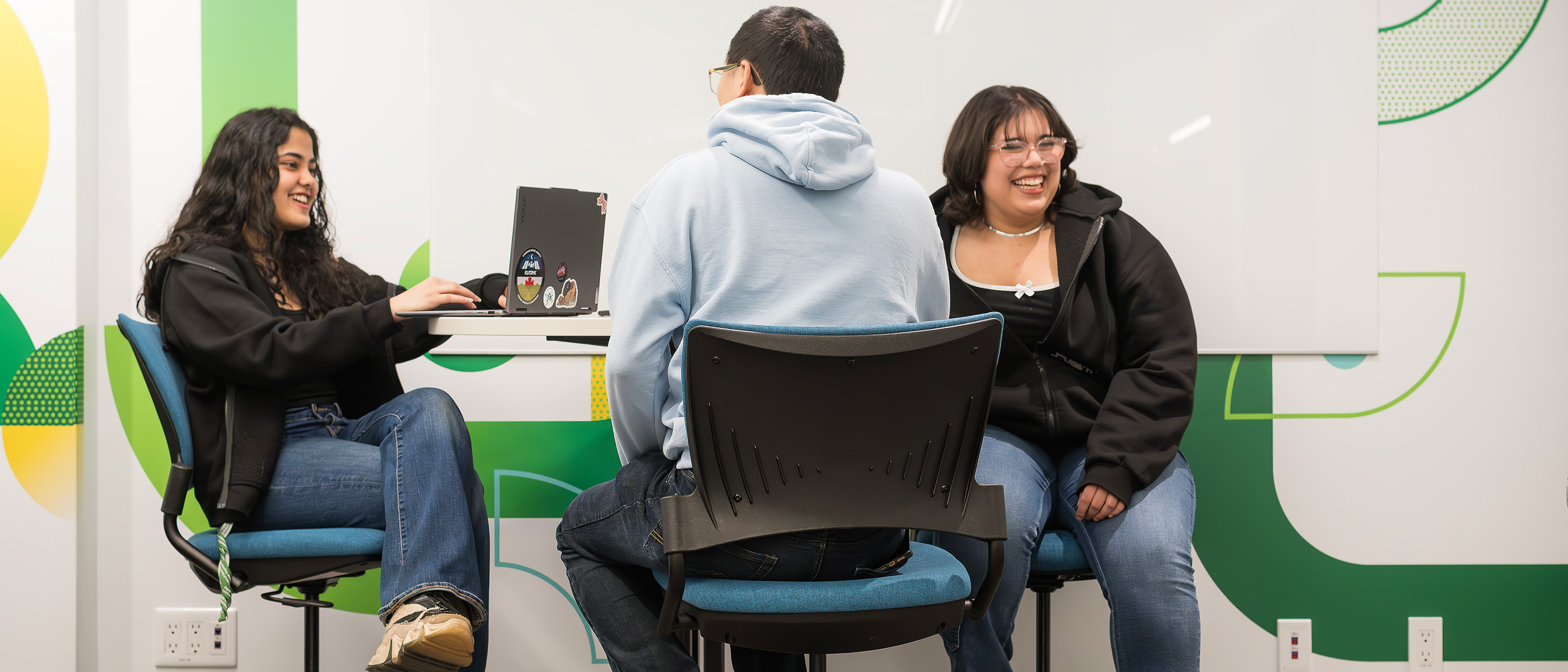 Students laugh while studying in a study area.