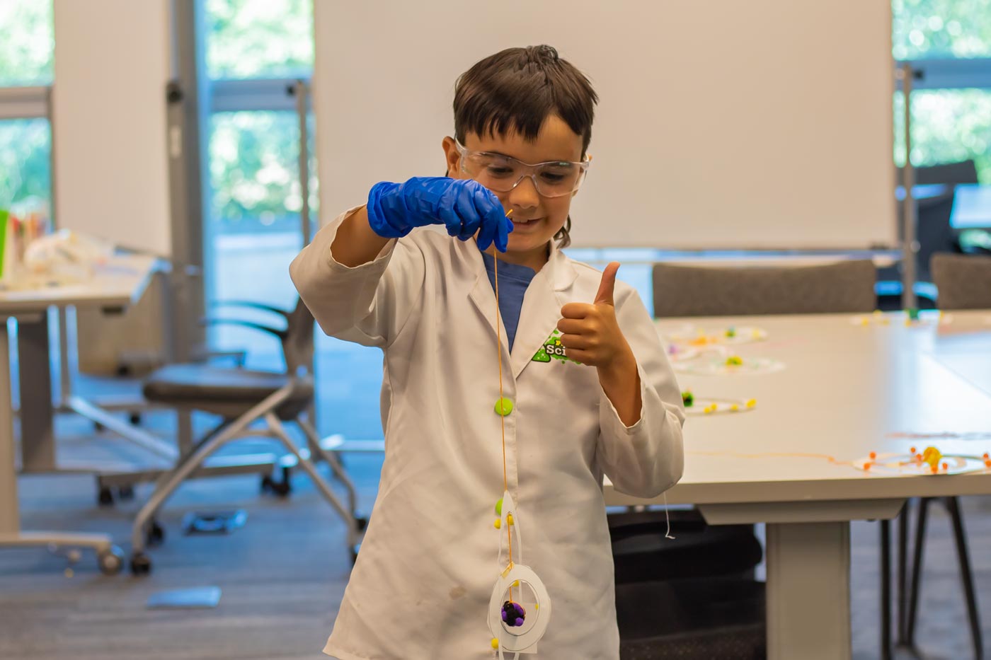 Child holding up a representation of an atom