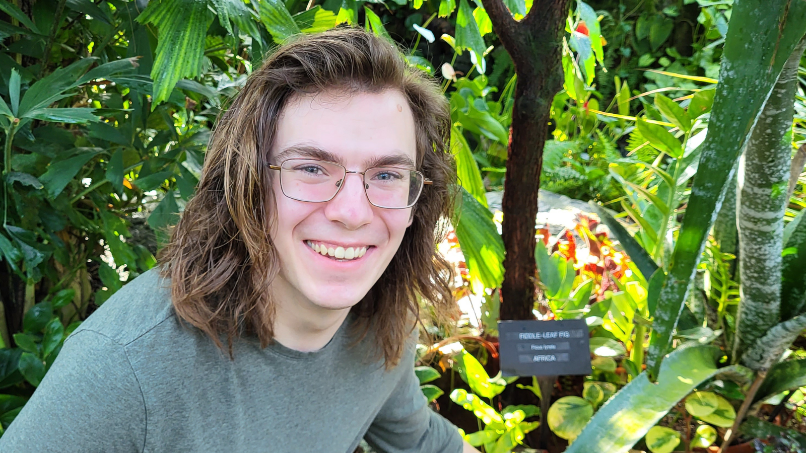 Portrait of Noah in front of some plants in a garden.