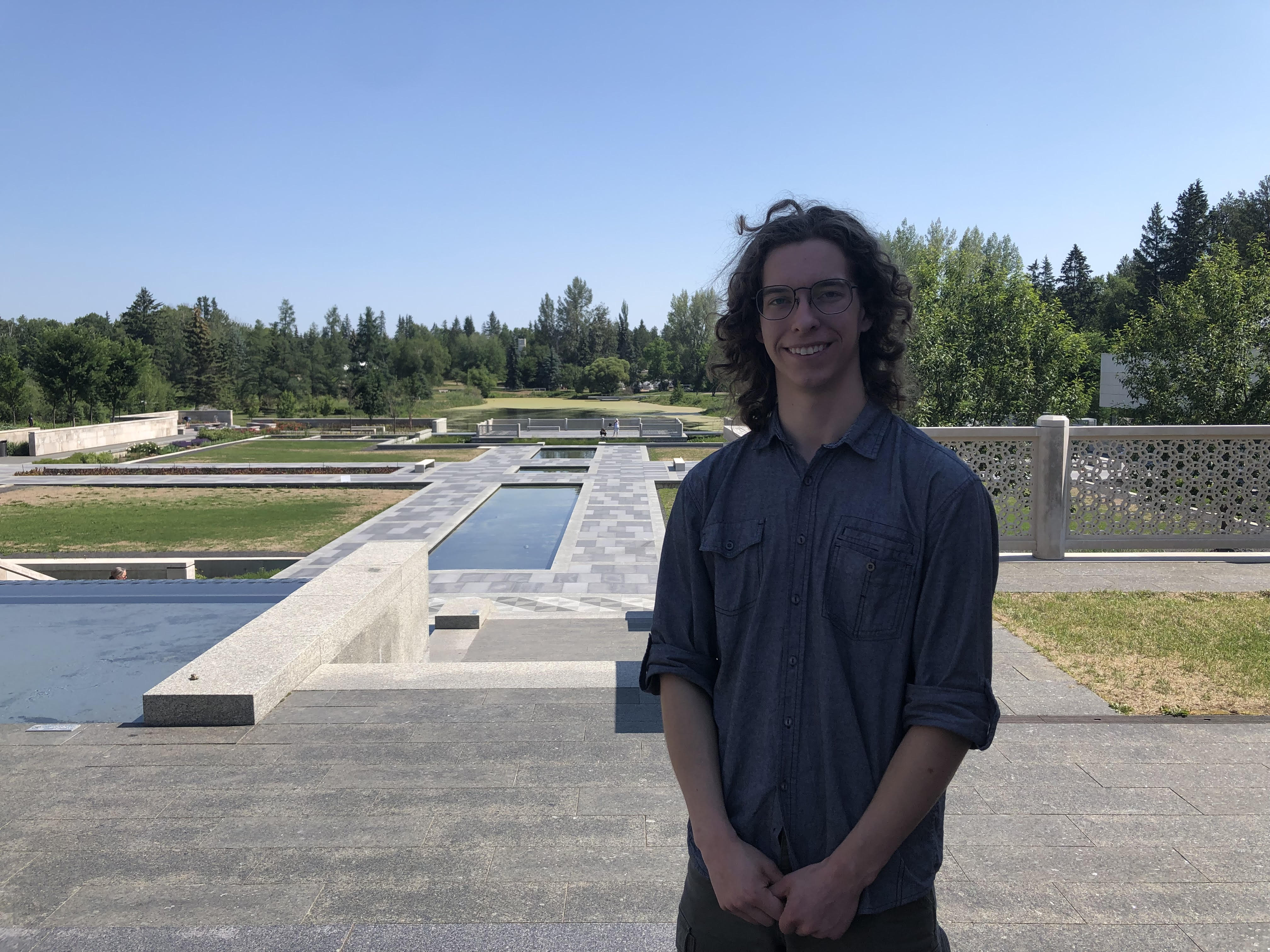 Jeremy Zittlau stands outside at the Aga Khan garden in the University of Alberta Botanical Garden. He is a 2023 recipient of the William Muir Edwards Award.