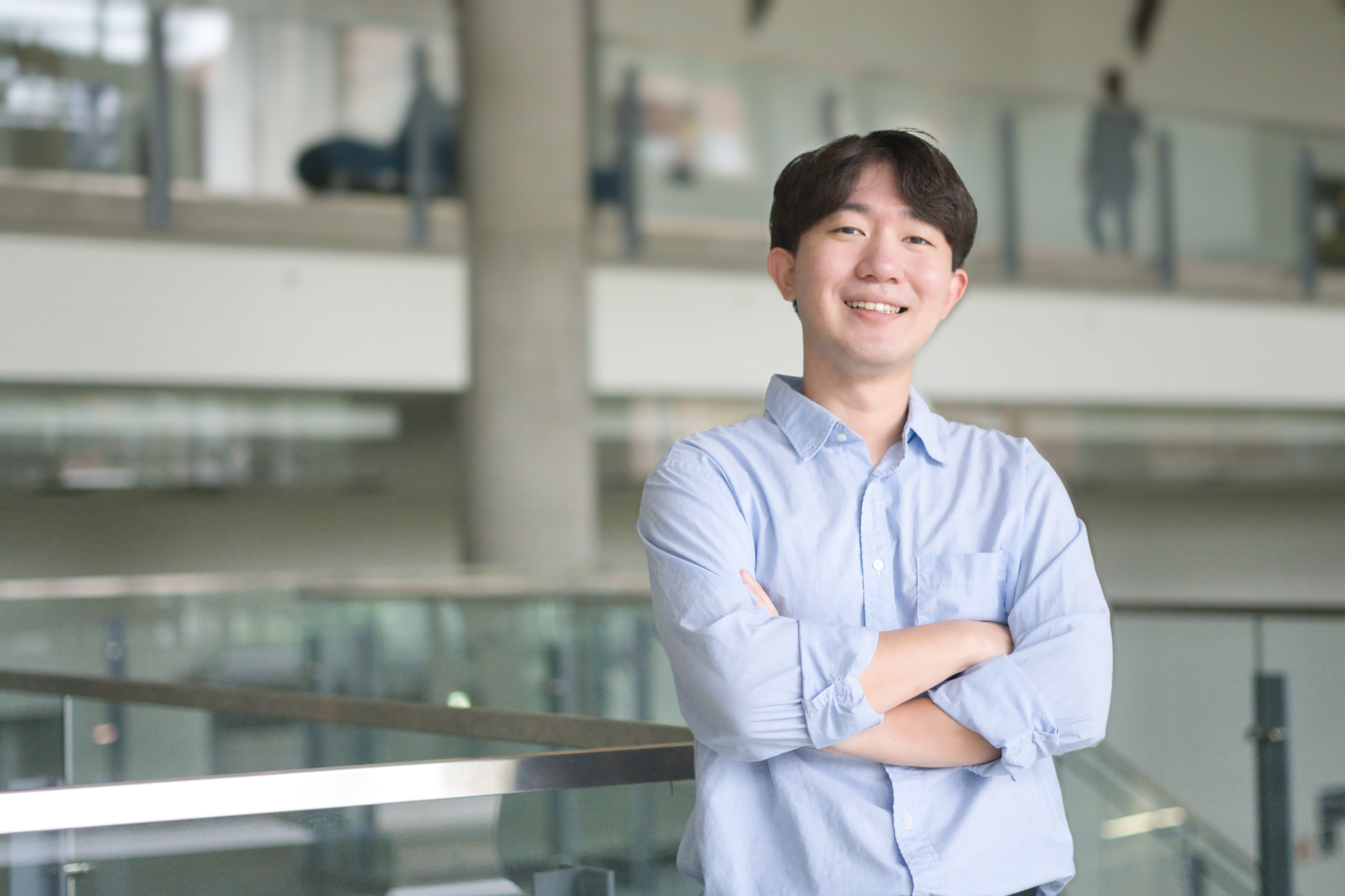 Taekwan Yoon standing with his arms crossed smilling. Taekwan is a 2023 recipient of the William Muir Edwards Award. 