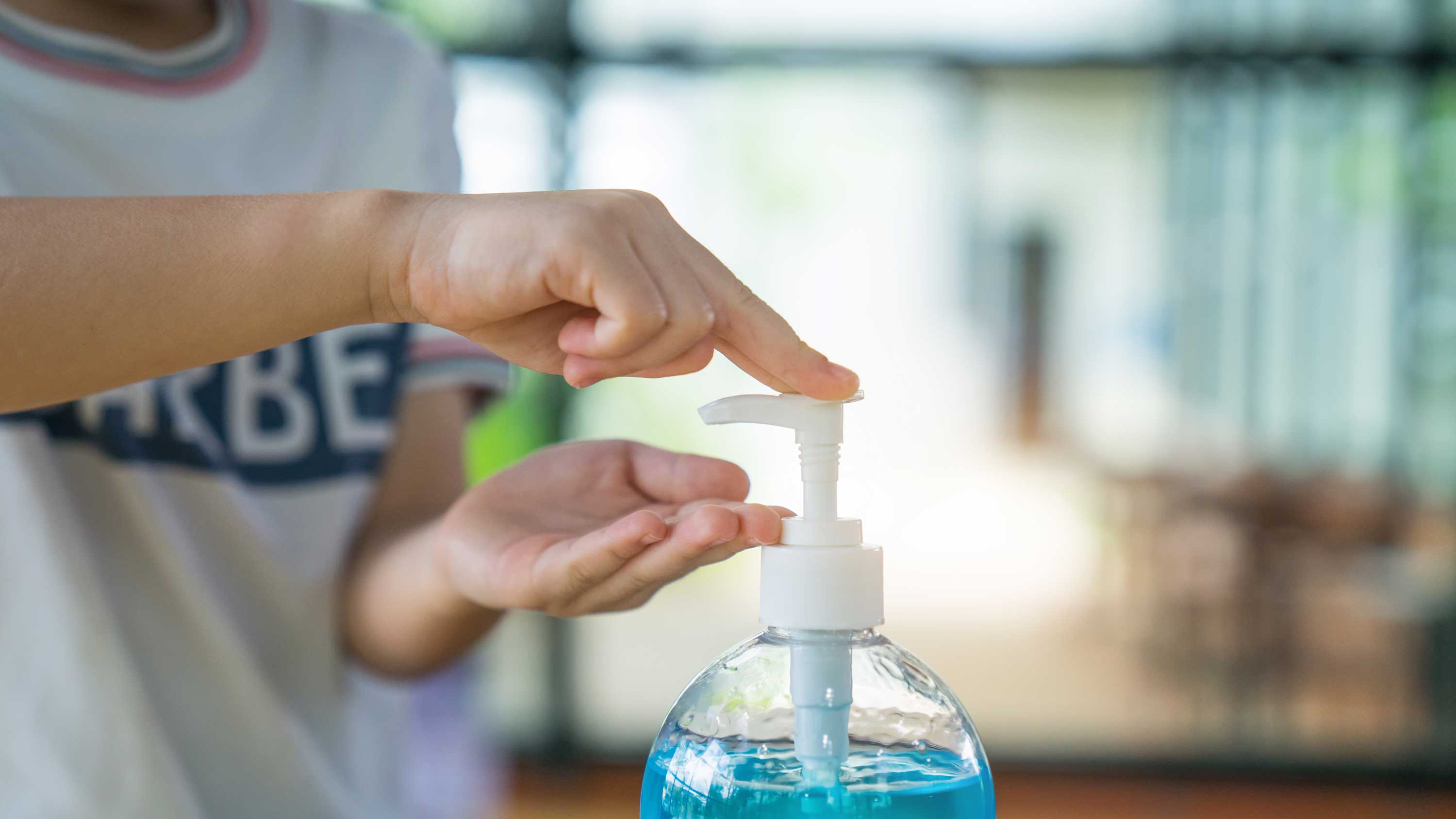 A child using hand sanitizer