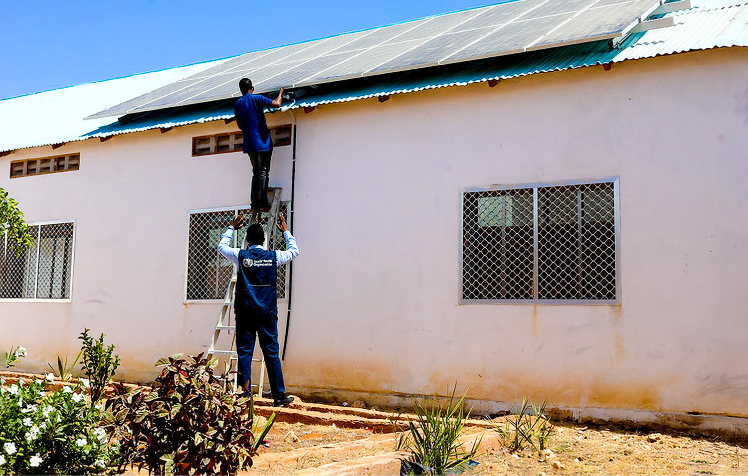 Workers install solar panels atop the roof of Hanaano General Hospital in Dusamareb, Somalia. (Photo: WHO Somalia)