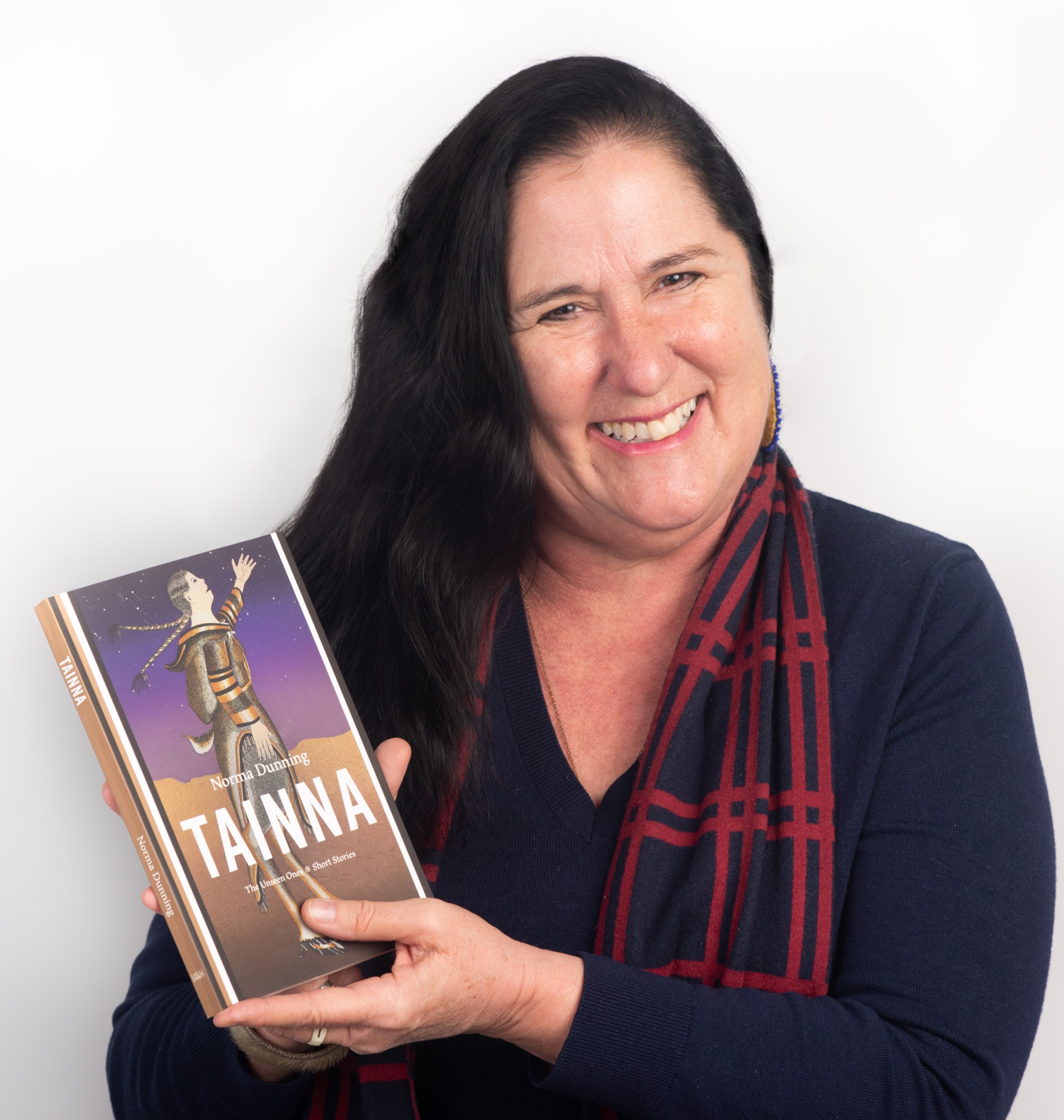 Norma Dunning holds a copy of her award-winning short story collection Tainna: The Unseen Ones