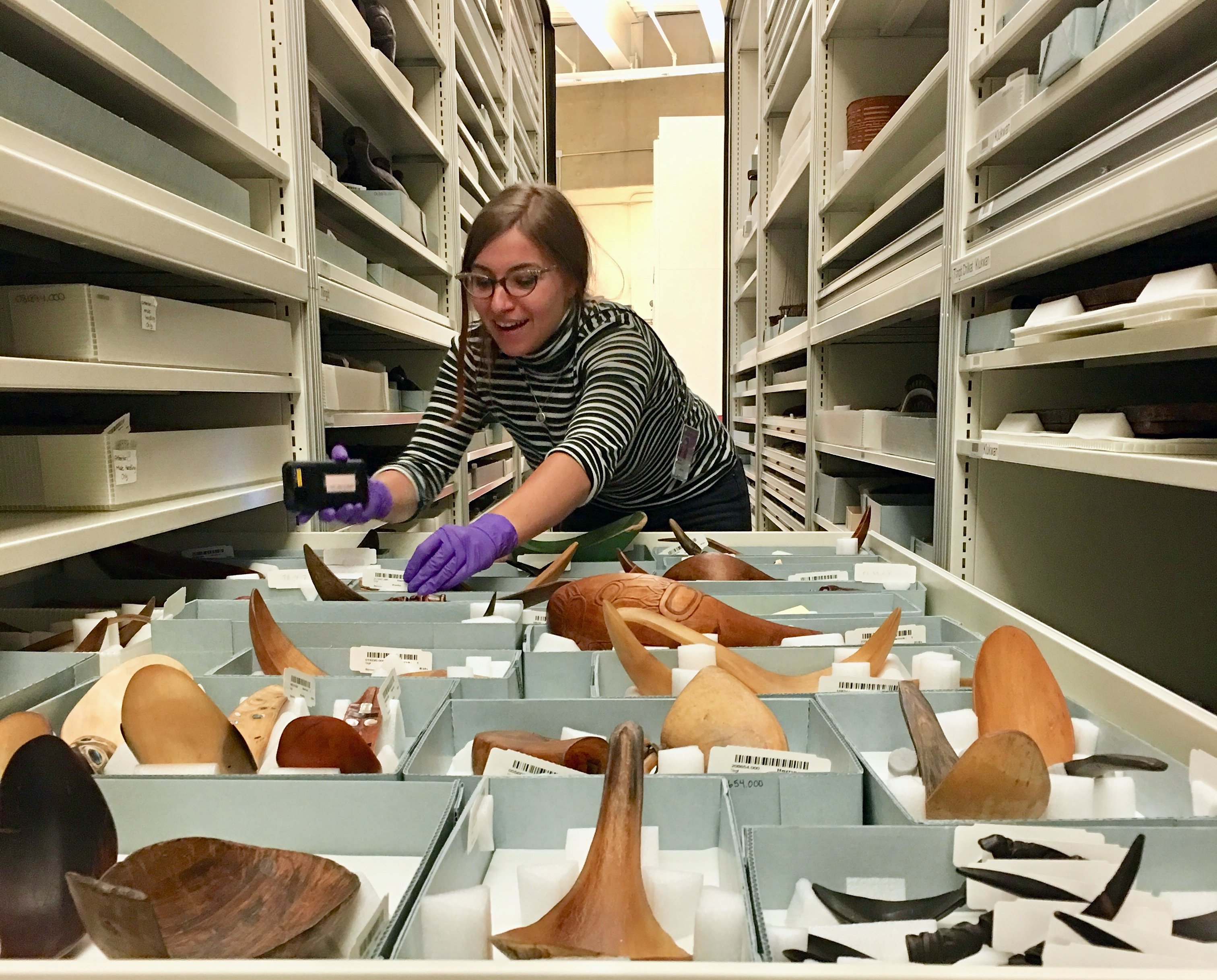 Lauren Comba works with a collection of spoons crafted by Indigenous peoples as part of her internship at the Smithsonian. (Photo: Supplied)