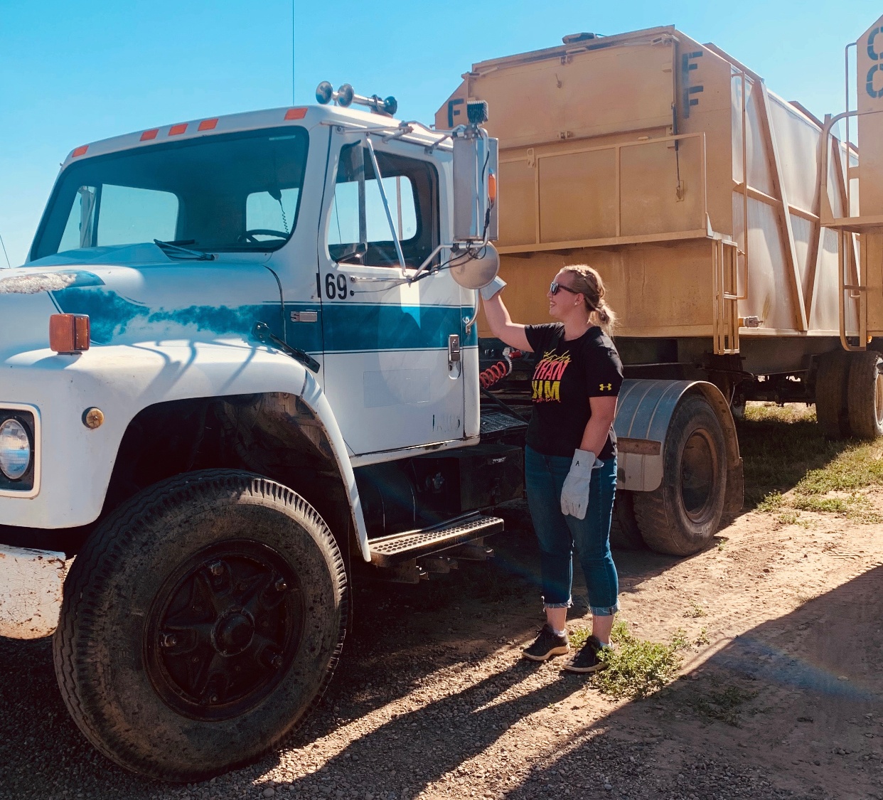 Agricultural business management student Adriana Van Tryp stands beside a tractor trailer on a farm. (Photo: Supplied)