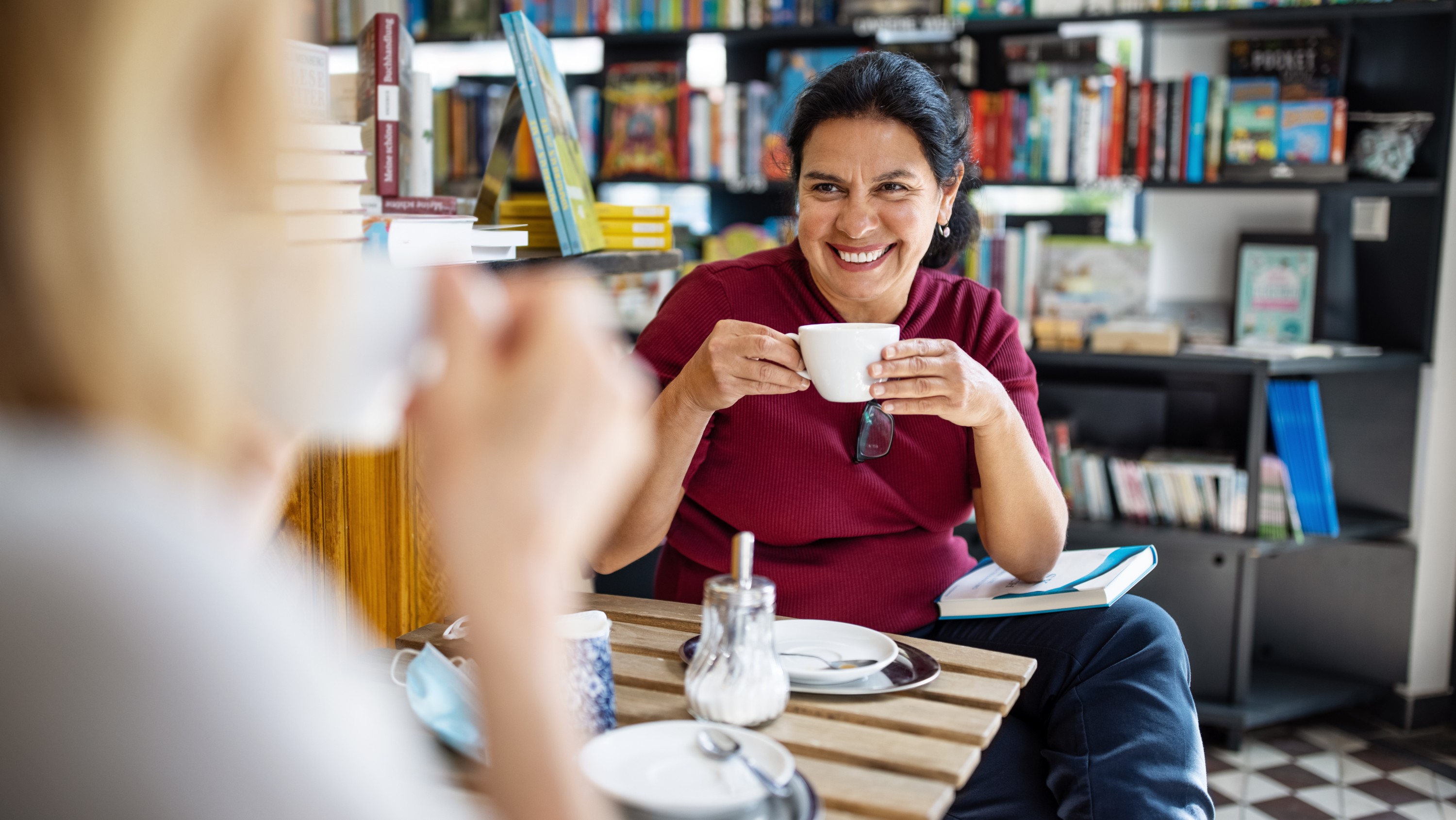 Woman drinks coffee in bookstore cafe. (Photo: Getty Images)