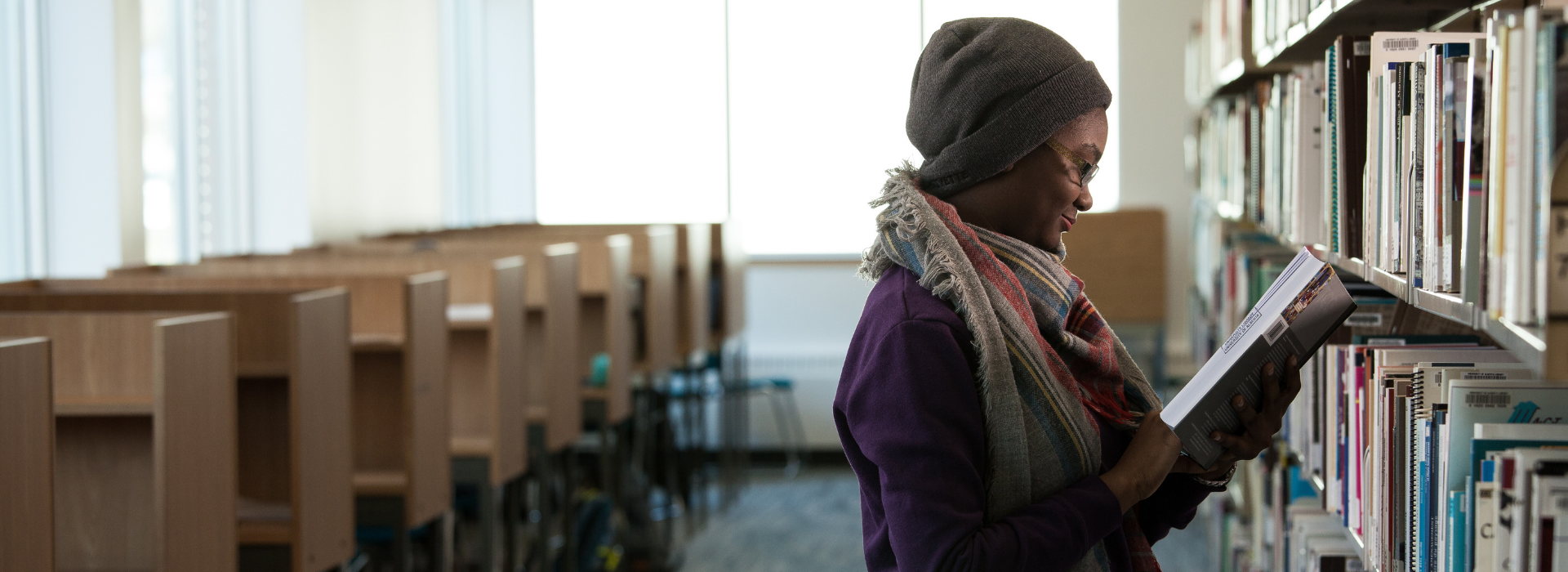 A student reading a book in the CSJ library