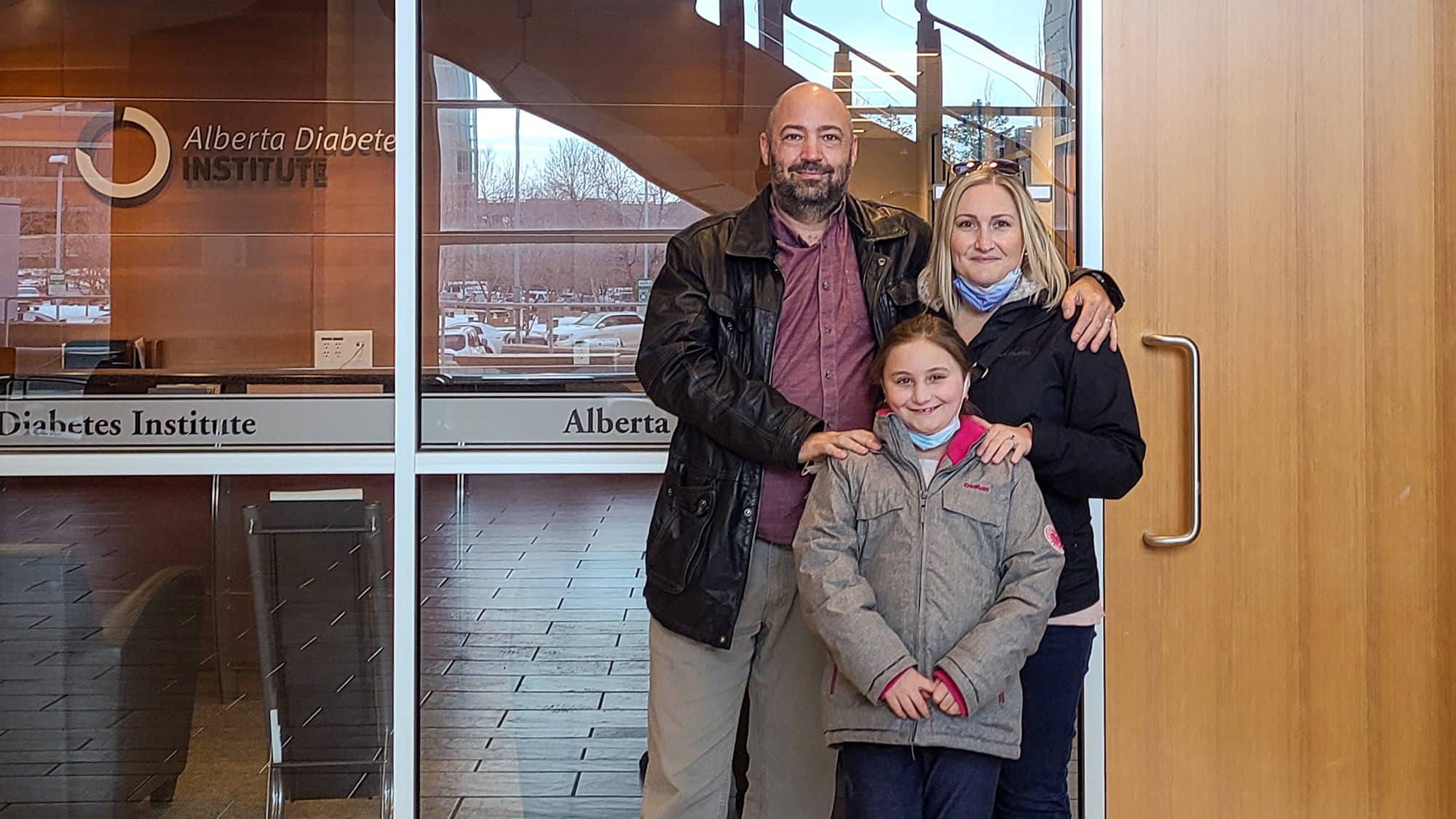 The Quinlan family standing in front of the Alberta Diabetes Institute