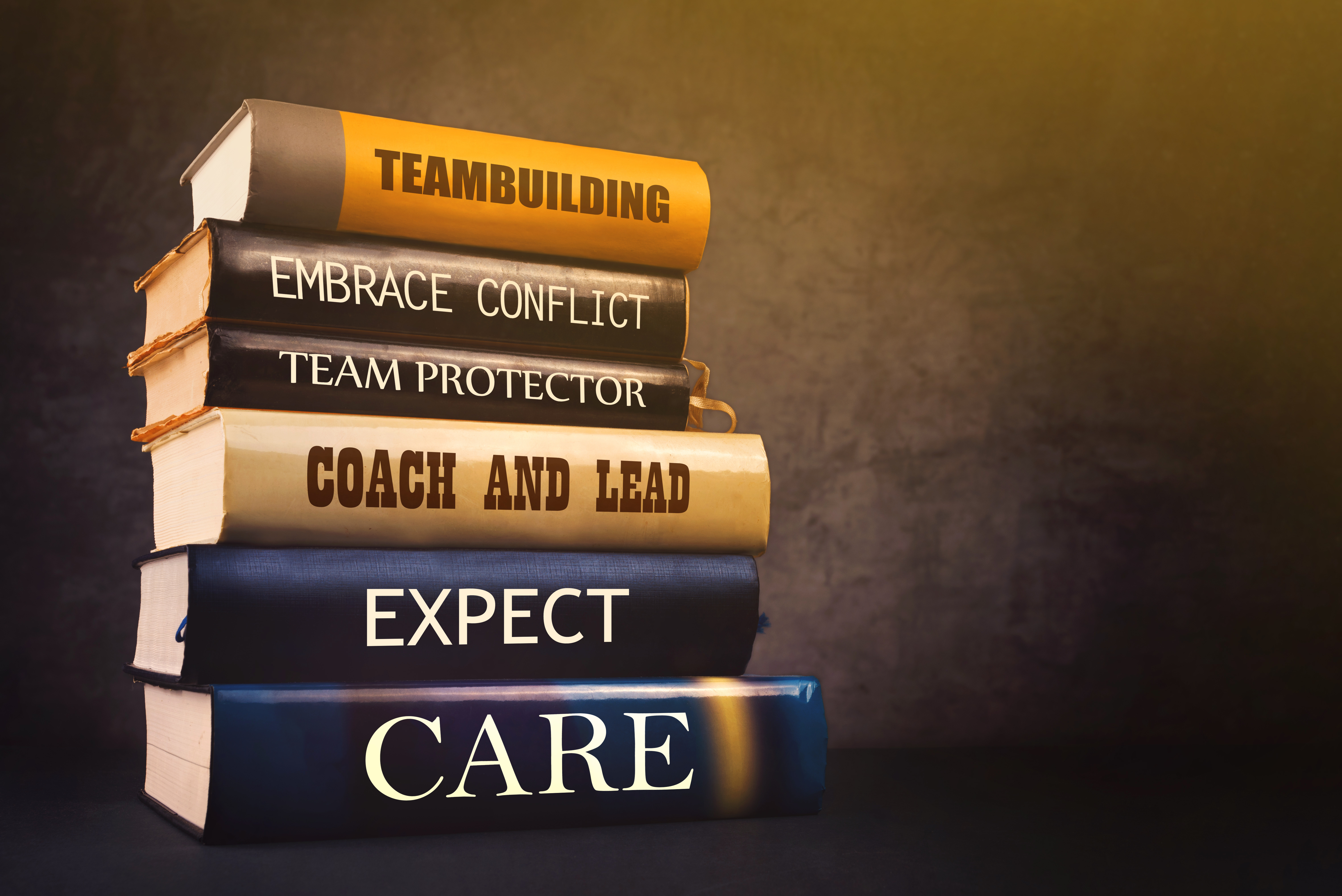 stack of books on coaching and team