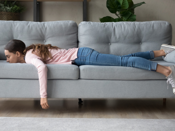 woman lying facing down on couch
