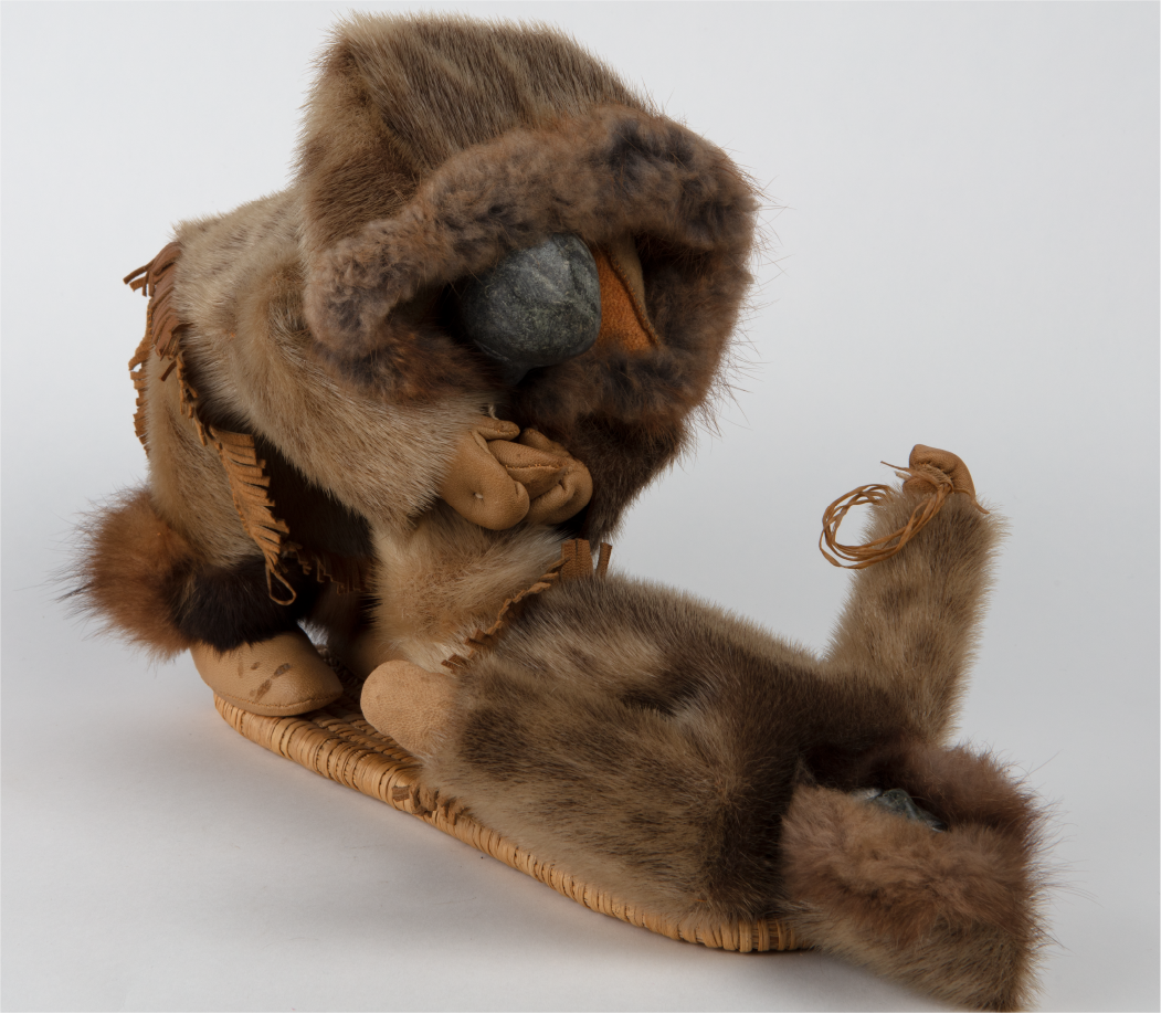 Inuit doll depicting a mother tying a child's shoe