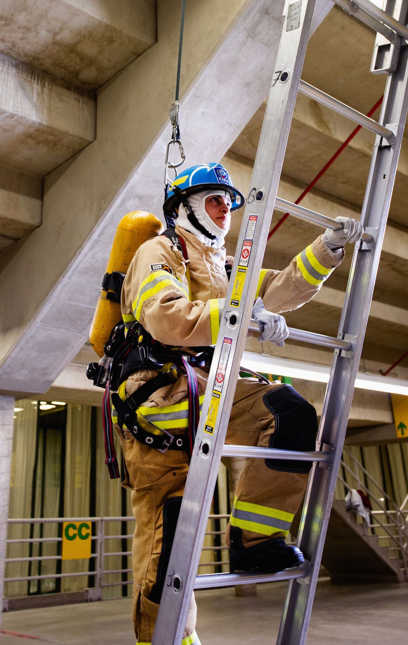 Applicant climbing a ladder in firefighting gear