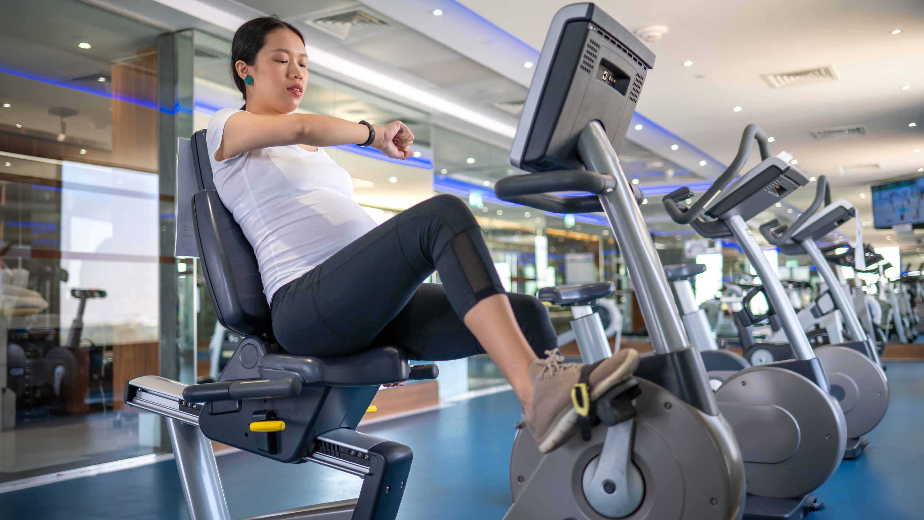 Pregnant person using a stationary bike for exercise