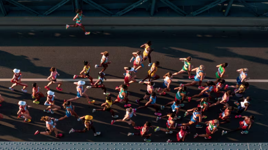 An aerial photo taken on Aug. 26, 2023, shows athletes as they compete in the women's marathon final during the World Athletics Championships in Budapest. Earlier in May, a video of a woman running the Presidente Prudente Half Marathon in Brazil went viral after her husband let her kids meet her on the course. (Istvan Ruzsa/Pool/AFP/Getty Images)