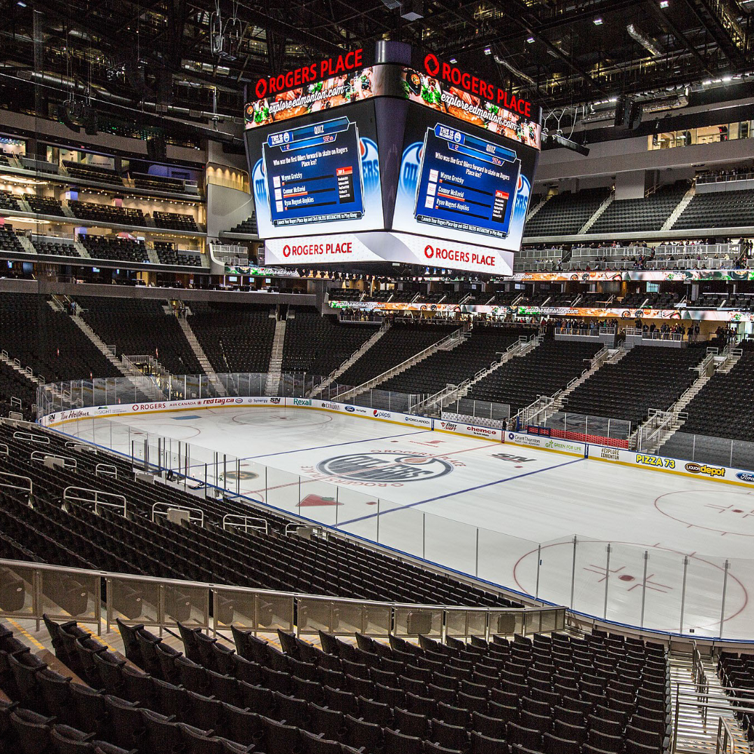 interior image of empty Rogers Arena in Edmonton featuring empty seats and a wide shot of the ice surface with Oilers logo at centre ice 