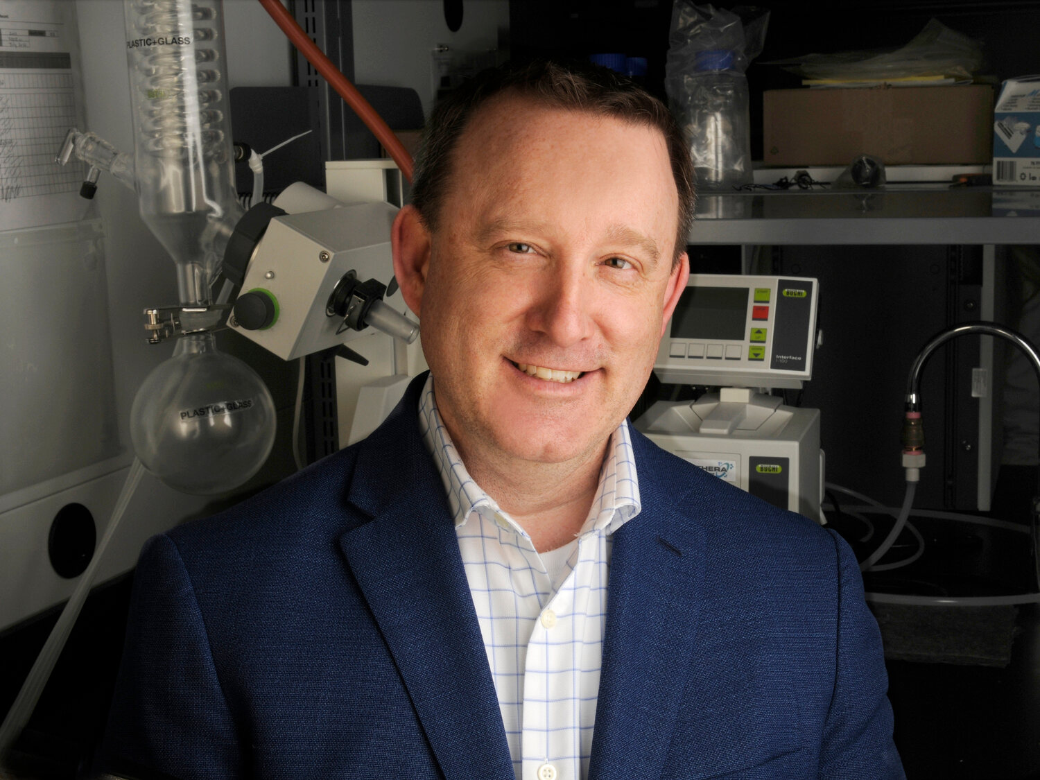 Headshot of Dr. Jason Acker in front of laboratory equipment.