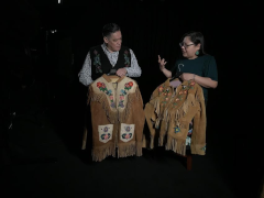 two people looking at beaded jackets