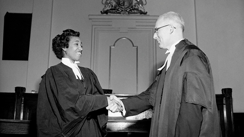 Violet Kind shakes hands with lawyer E.J. McCormick, with whom she articled.
