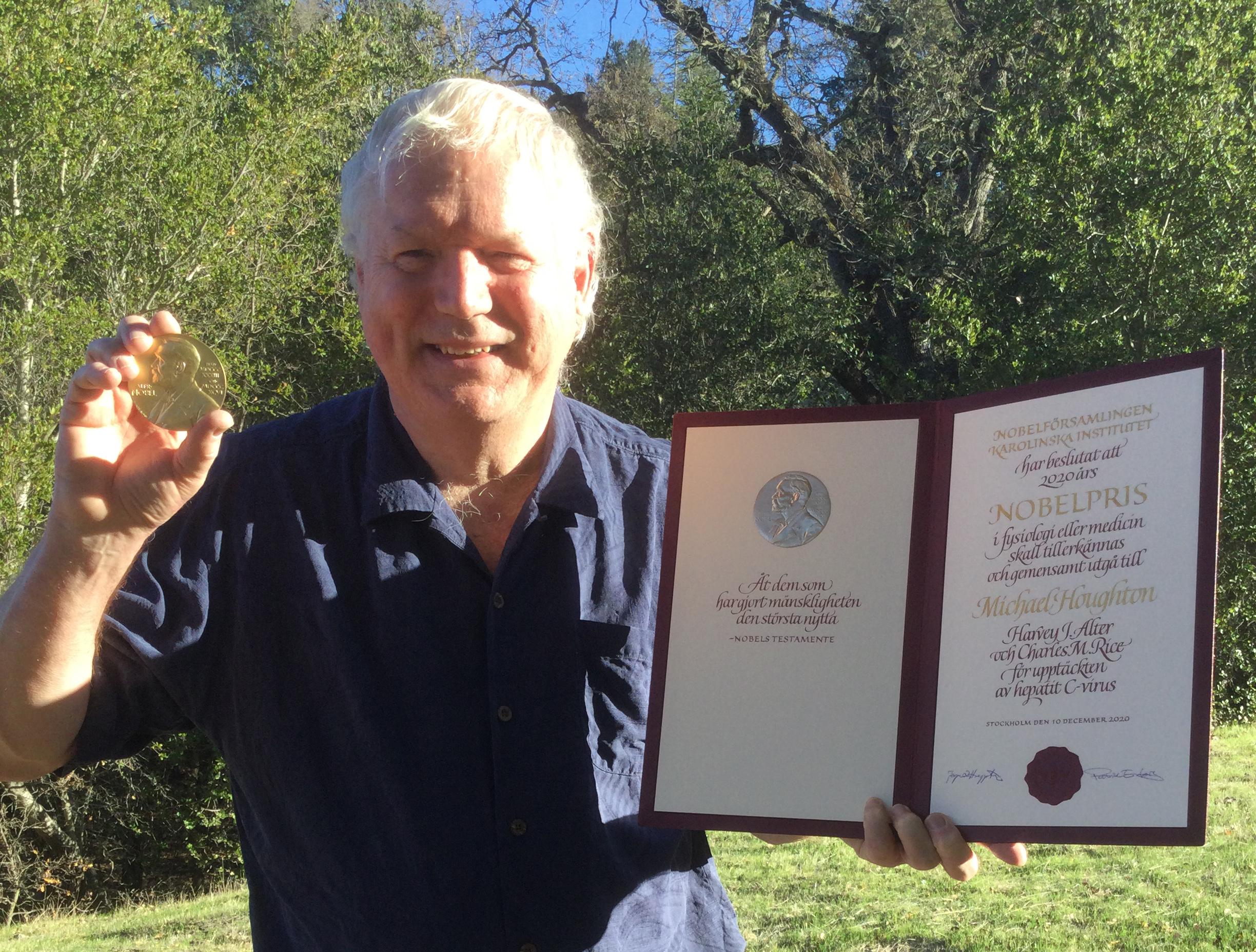 Dr. Michael Houghton holding the Nobel Prize in his backyard.