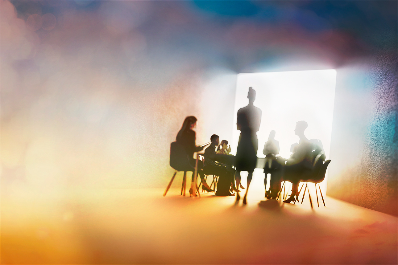 Artistic silhouette of a boardroom with people seated and one figure standing. A bright window at the back of the room makes everyone a shadow.
