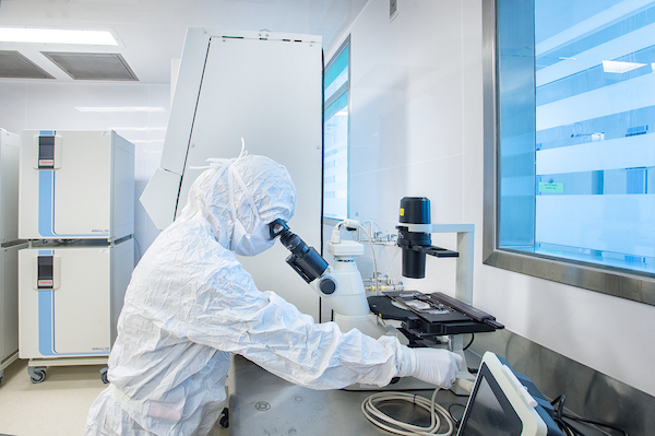Cleanroom personnel looking in microscope